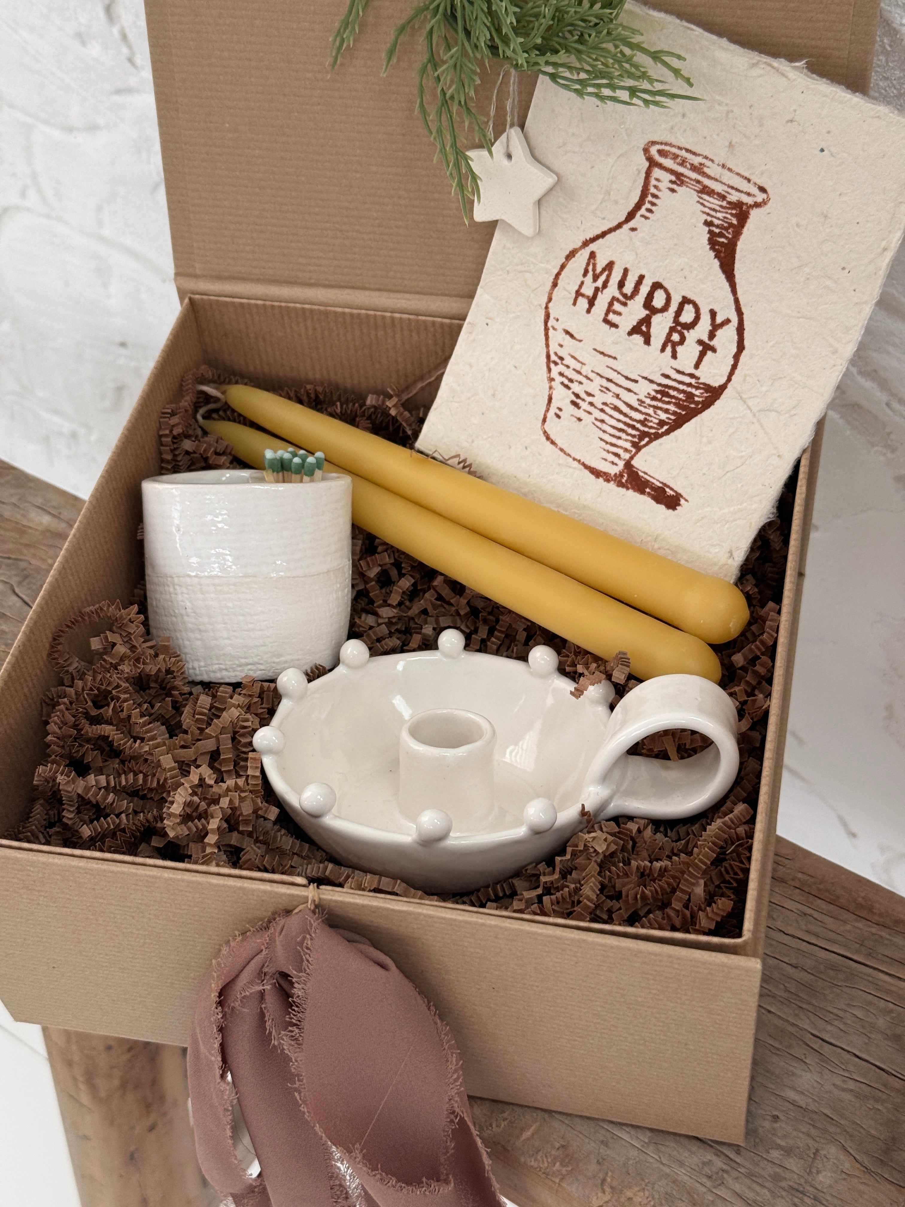 Handmade ceramic candle holder with a pair of beeswax candles and a ceramic match striker, arranged as a gift set.