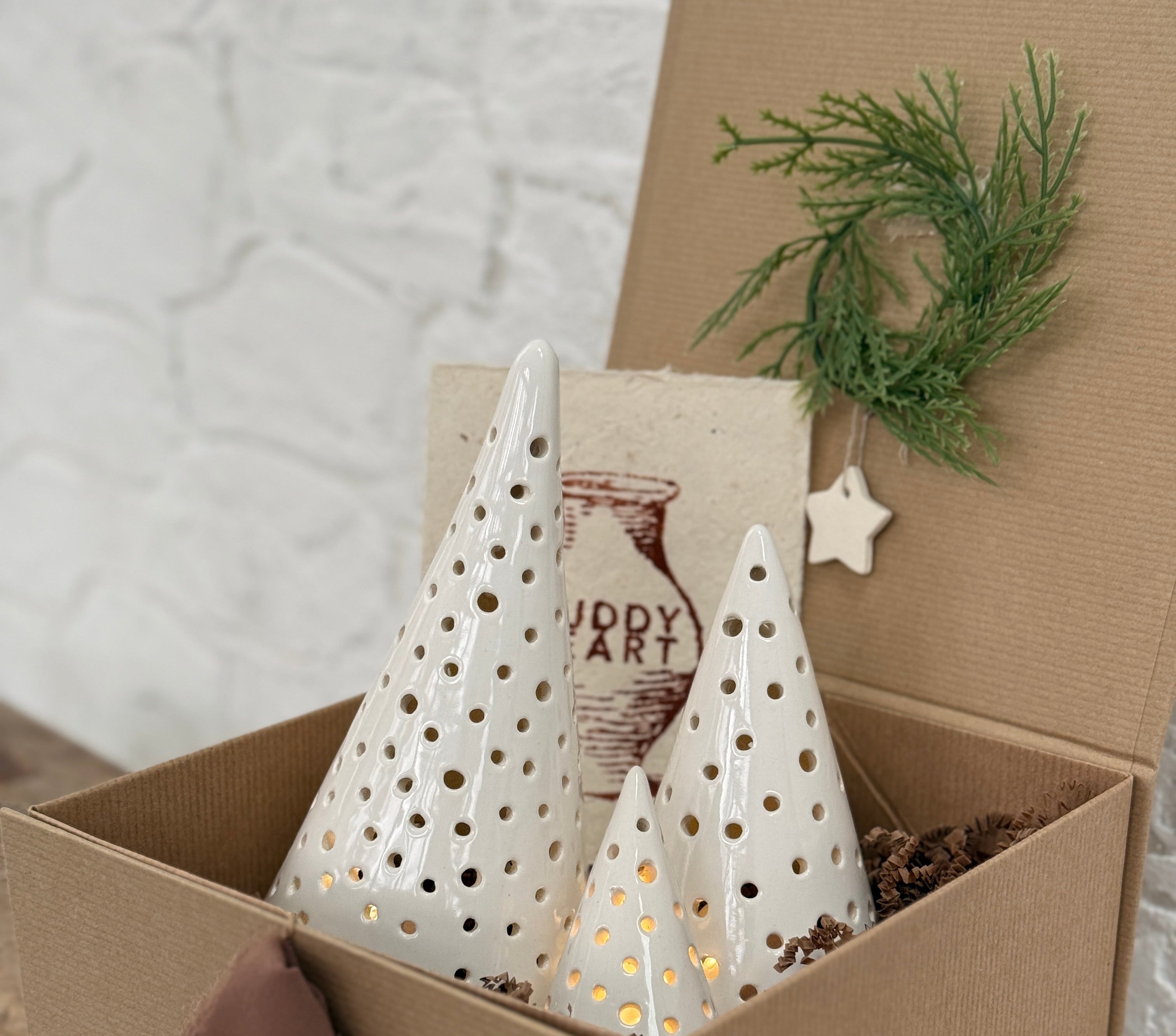 Handmade ceramic luminary tree set glowing with LED tea lights in a ready-to-gift holiday box.