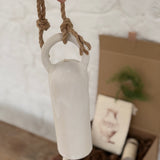 Long handmade ceramic bell in a frost white finish with a solid wood wall peg.