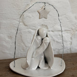 Handmade white ceramic nativity with a delicate star arch, softly sculpted in a minimal modern form.