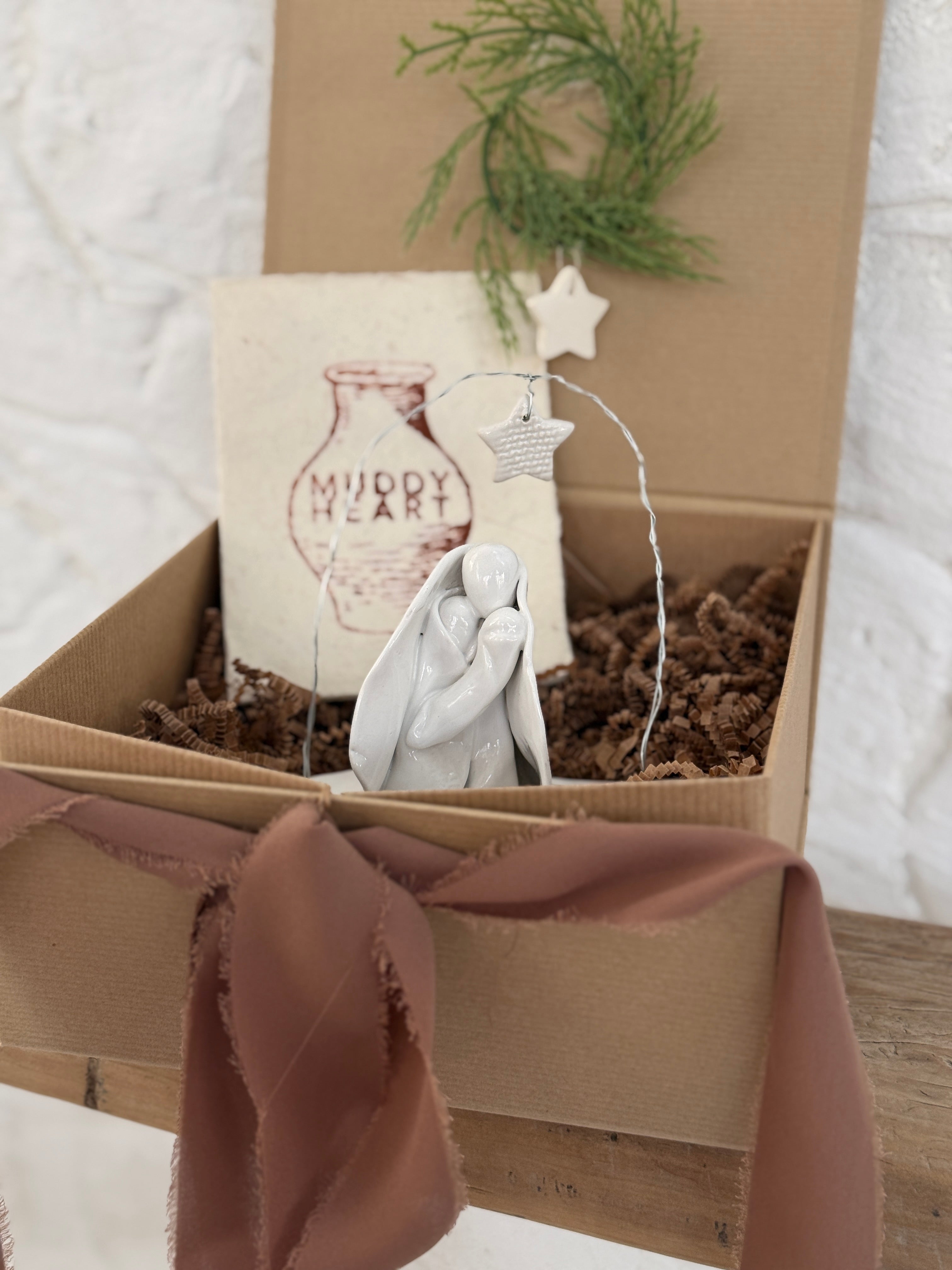 Handmade white ceramic nativity with a delicate star arch, softly sculpted in a minimal modern form.