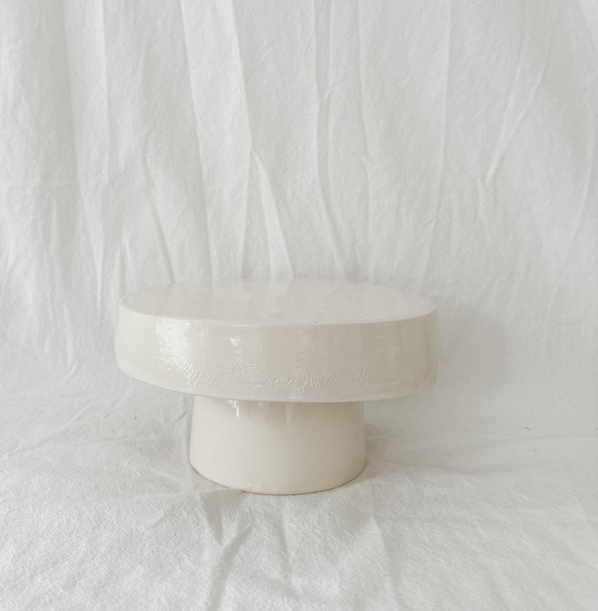 Handmade white ceramic cake stand with a delicate lace-textured plate in glossy white glaze, made to order by Muddy Heart