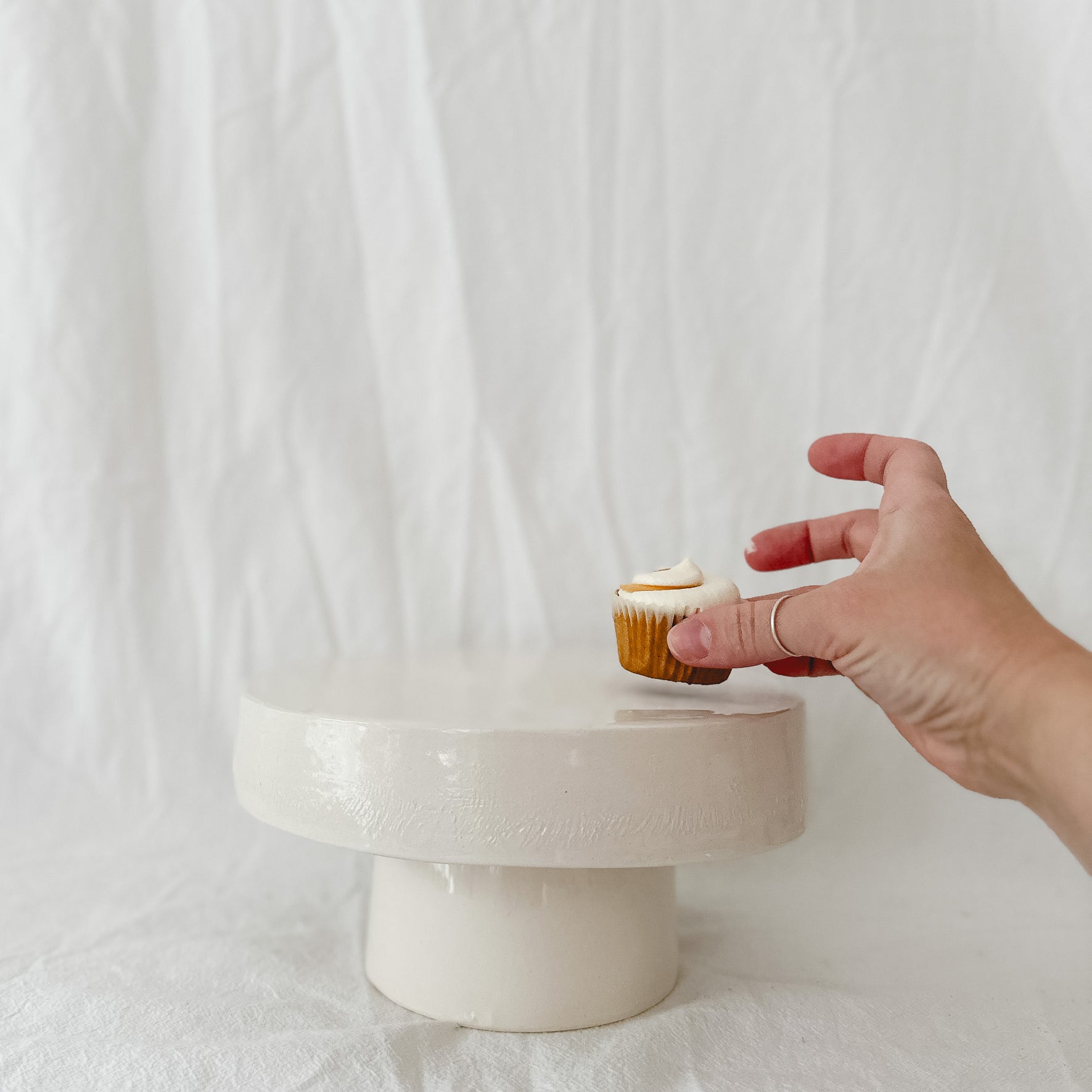 Handmade white ceramic cake stand with a delicate lace-textured plate in glossy white glaze, made to order by Muddy Heart