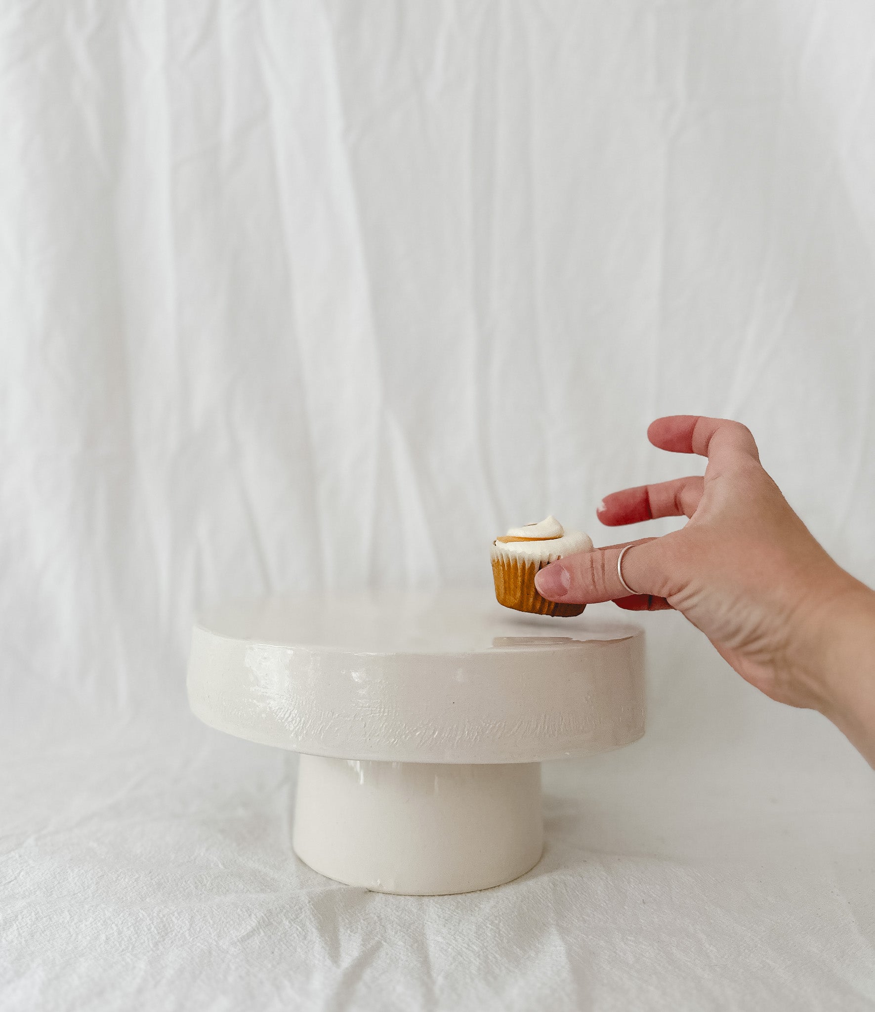 Handmade white ceramic cake stand with a delicate lace-textured plate in glossy white glaze, made to order by Muddy Heart