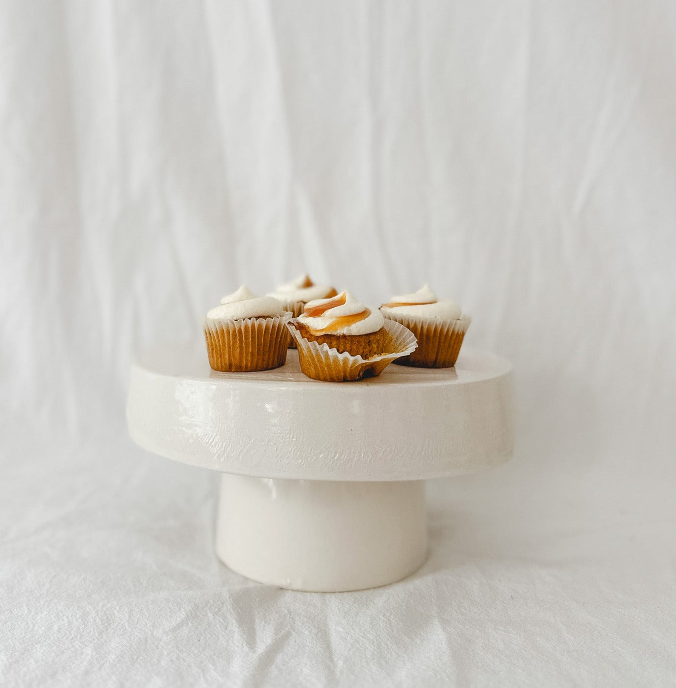 Handmade white ceramic cake stand with a delicate lace-textured plate in glossy white glaze, made to order by Muddy Heart