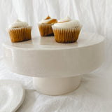 Handmade white ceramic cake stand with a delicate lace-textured plate in glossy white glaze, made to order by Muddy Heart