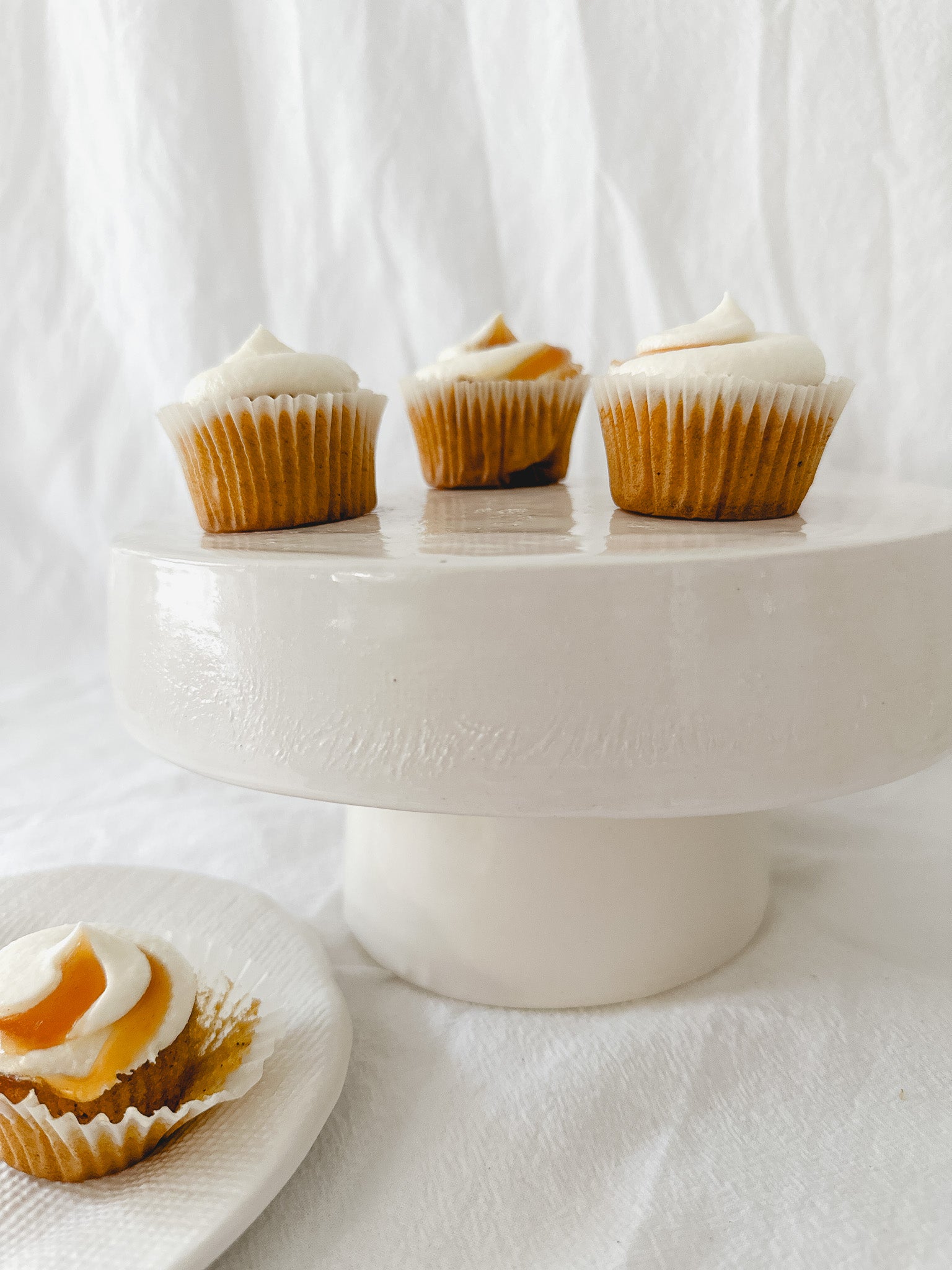 Handmade white ceramic cake stand with a delicate lace-textured plate in glossy white glaze, made to order by Muddy Heart