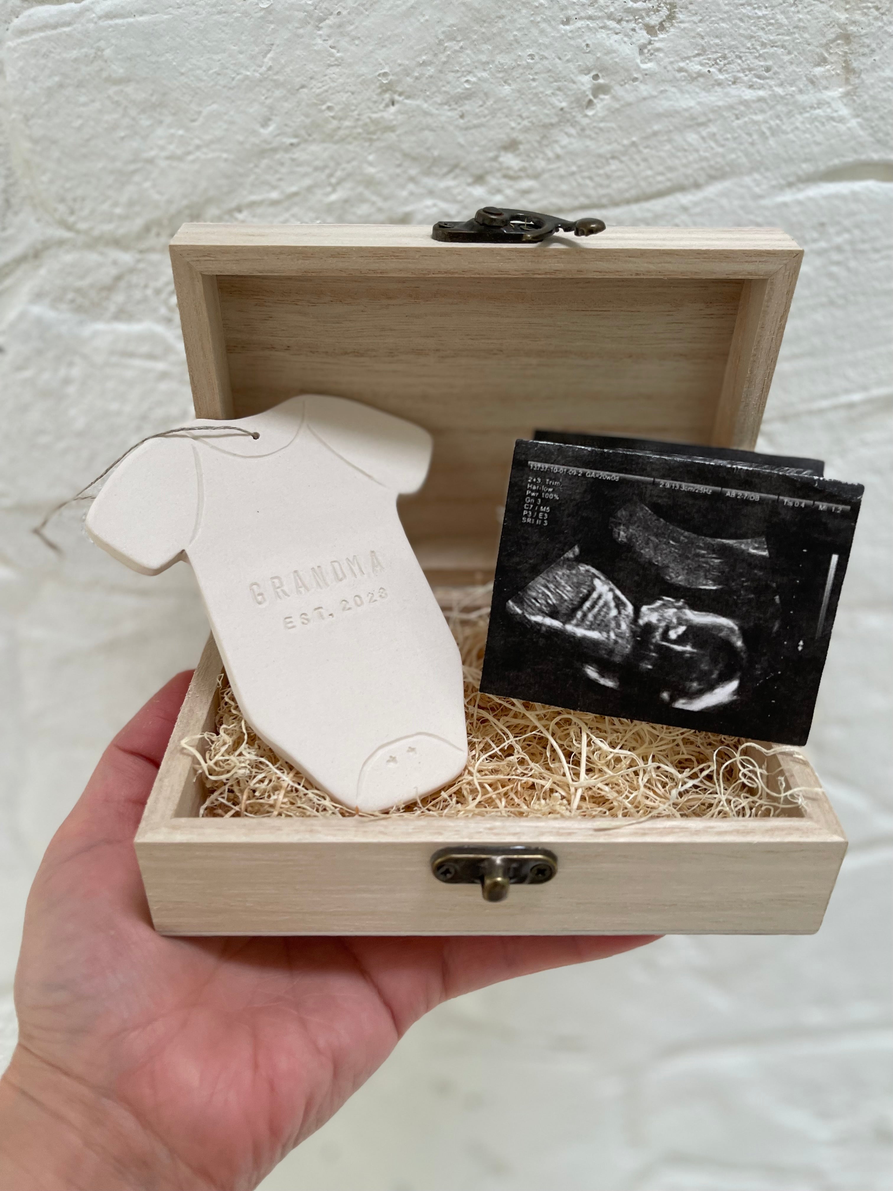 Custom porcelain baby announcement ornament and gift set presented in a wooden keepsake box