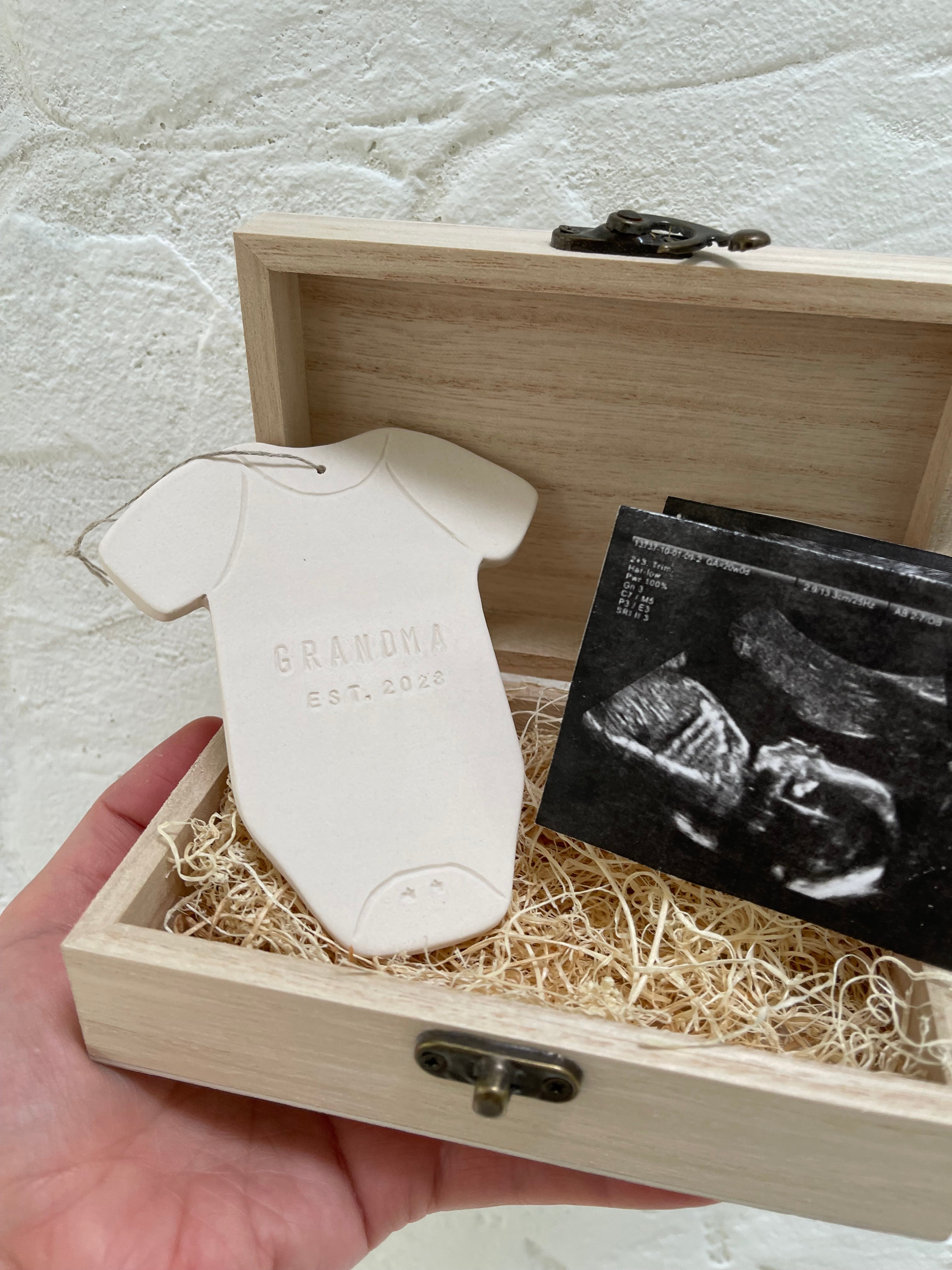 Personalized ceramic baby announcement ornament with an ultrasound photo, a keepsake for new grandparents