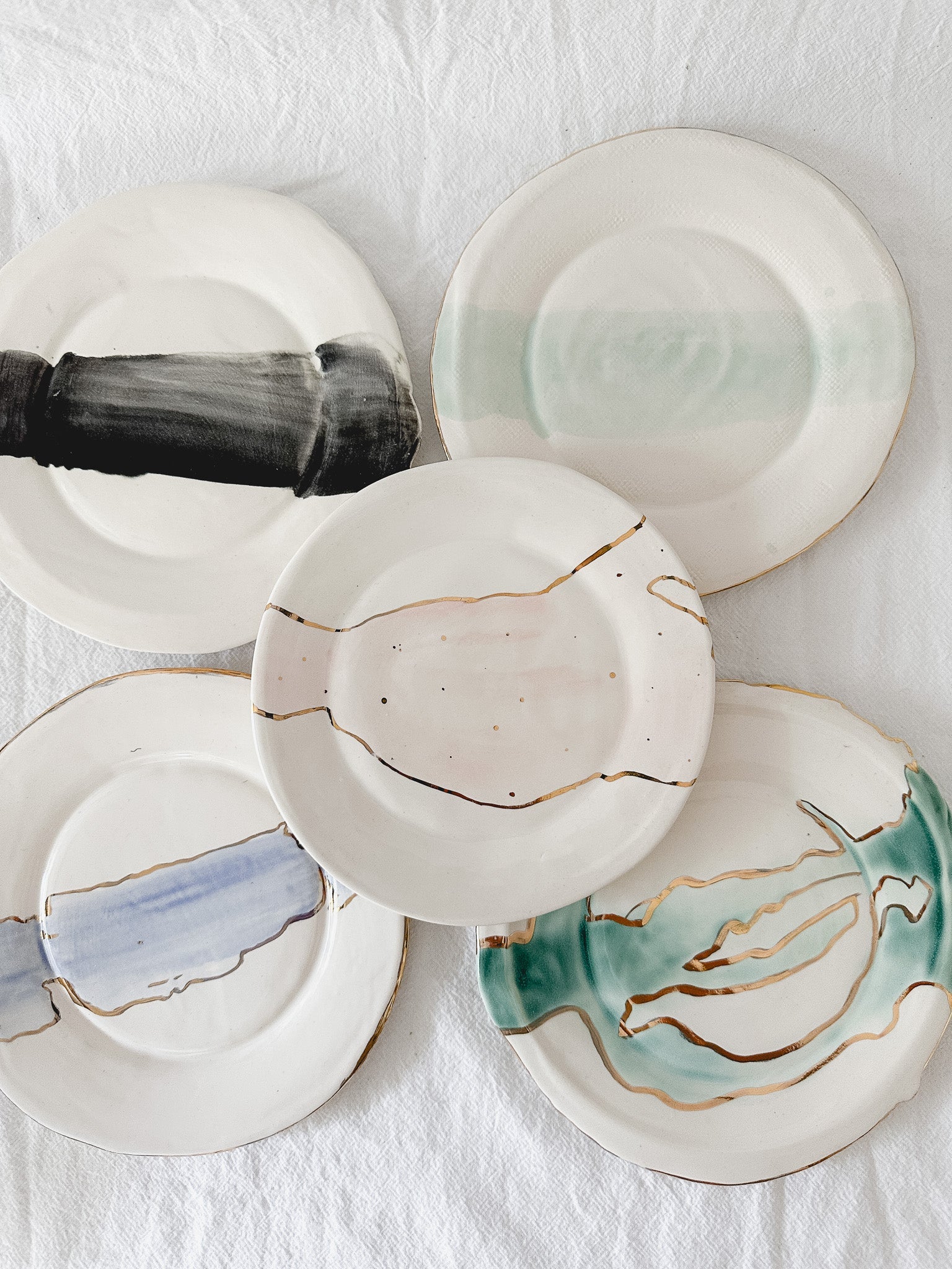 Handmade ceramic salad and dessert dishes with a watercolor glaze and real 22k gold luster line, seconds-sale pieces from Muddy Heart