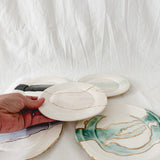 Handmade ceramic salad and dessert dishes with a watercolor glaze and real 22k gold luster line, seconds-sale pieces from Muddy Heart