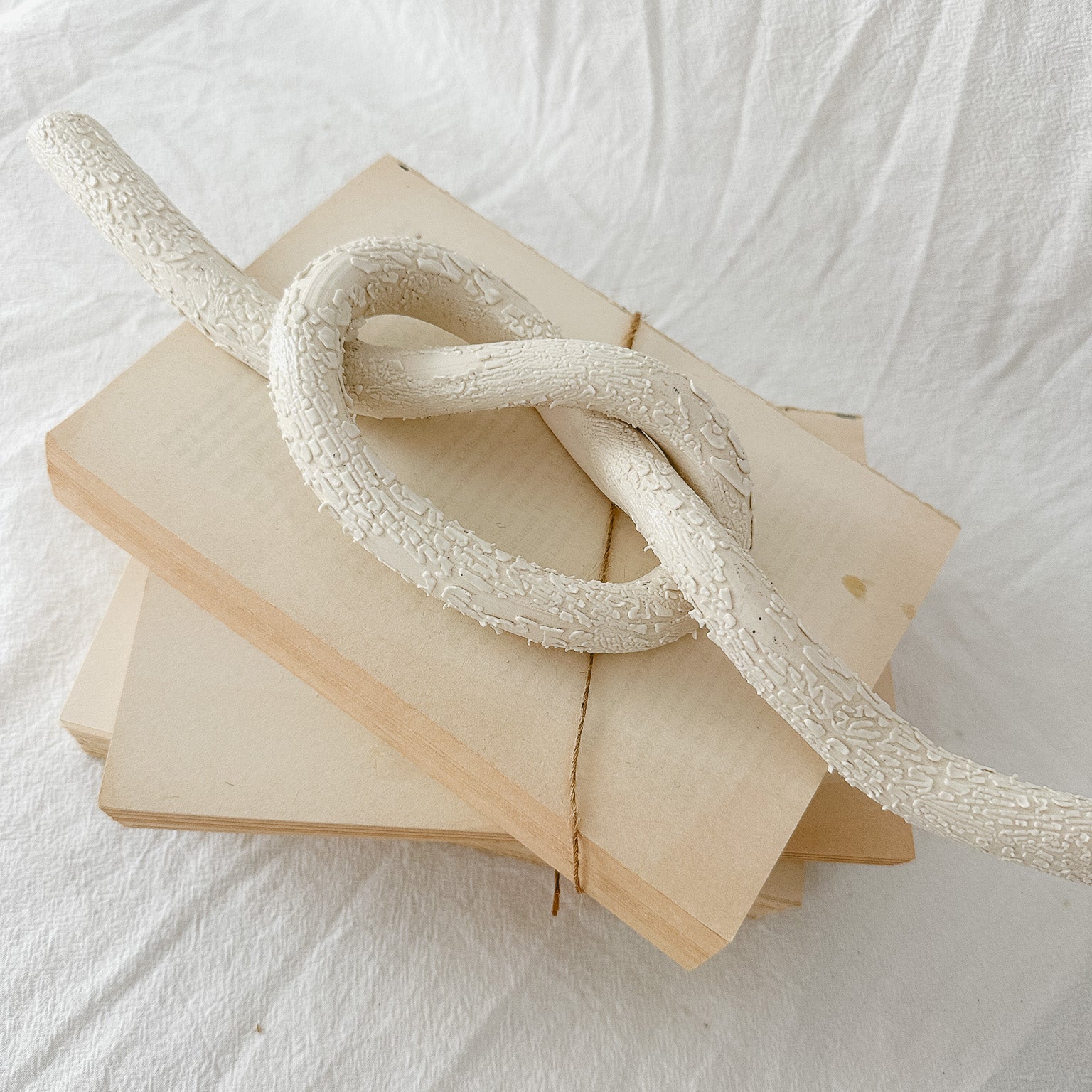 Handmade ceramic love knot decor object in textured white glaze, 12 inches long, one-of-a-kind piece from Muddy Heart