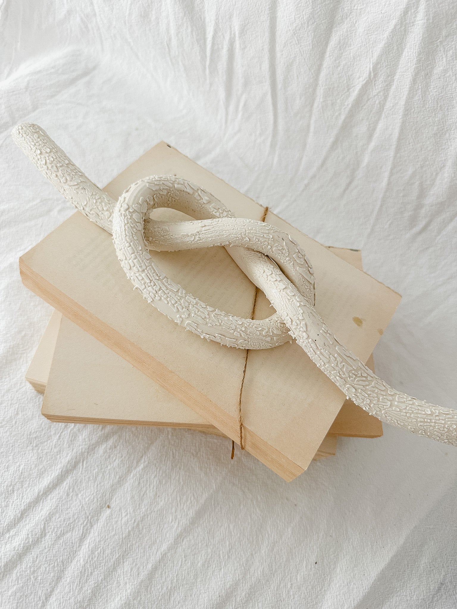 Handmade ceramic love knot decor object in textured white glaze, 12 inches long, one-of-a-kind piece from Muddy Heart