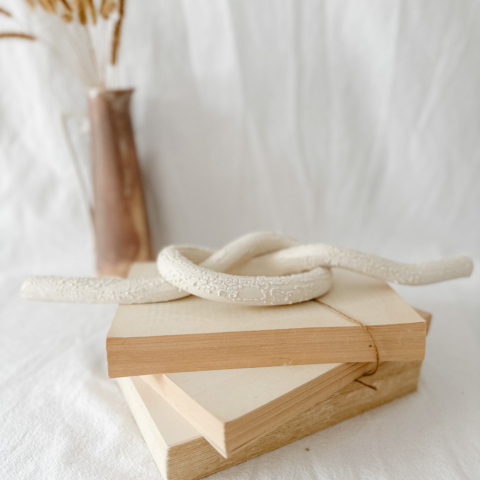 Handmade ceramic love knot decor object in textured white glaze, 12 inches long, one-of-a-kind piece from Muddy Heart