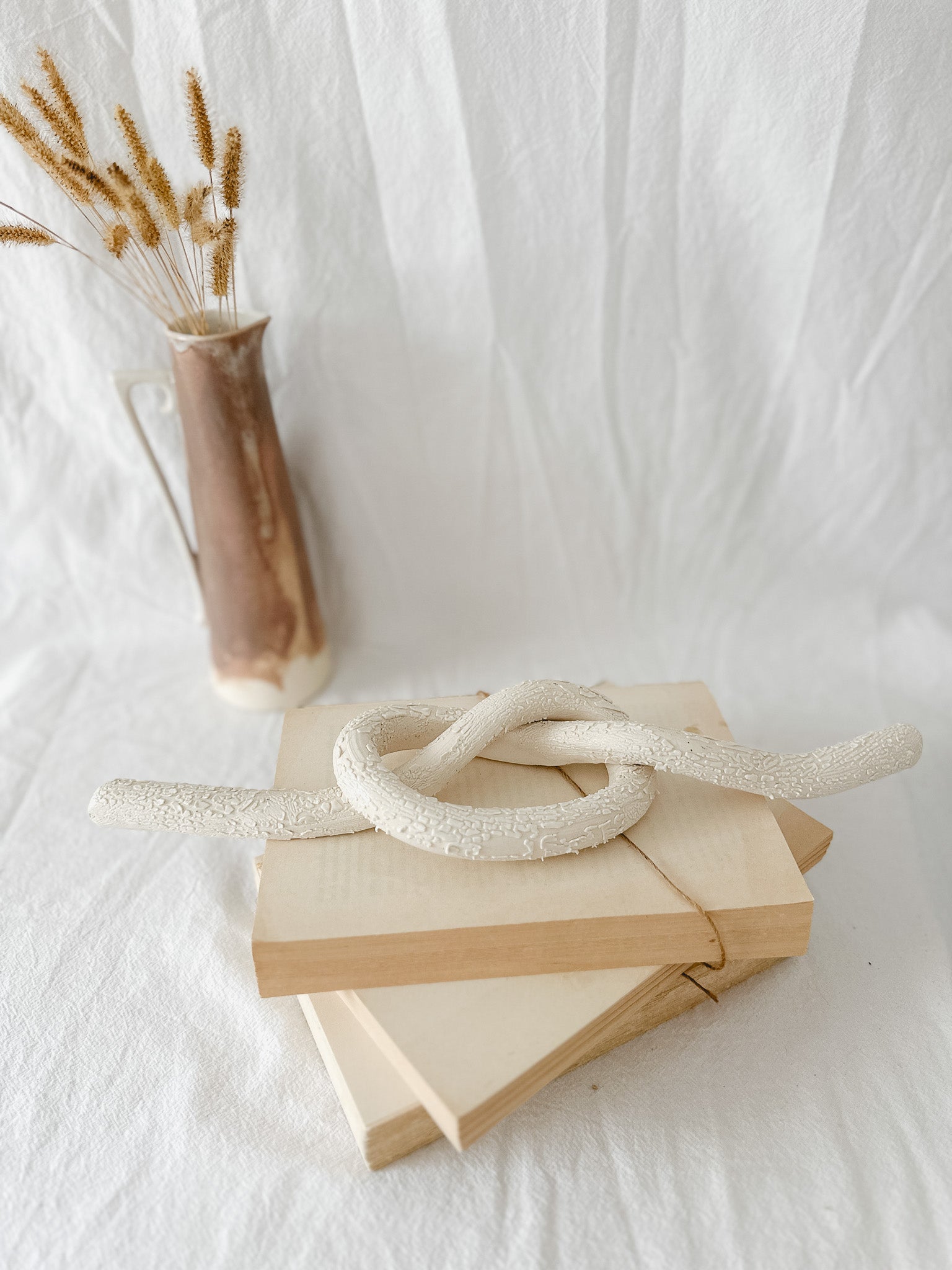 Handmade ceramic love knot decor object in textured white glaze, 12 inches long, one-of-a-kind piece from Muddy Heart