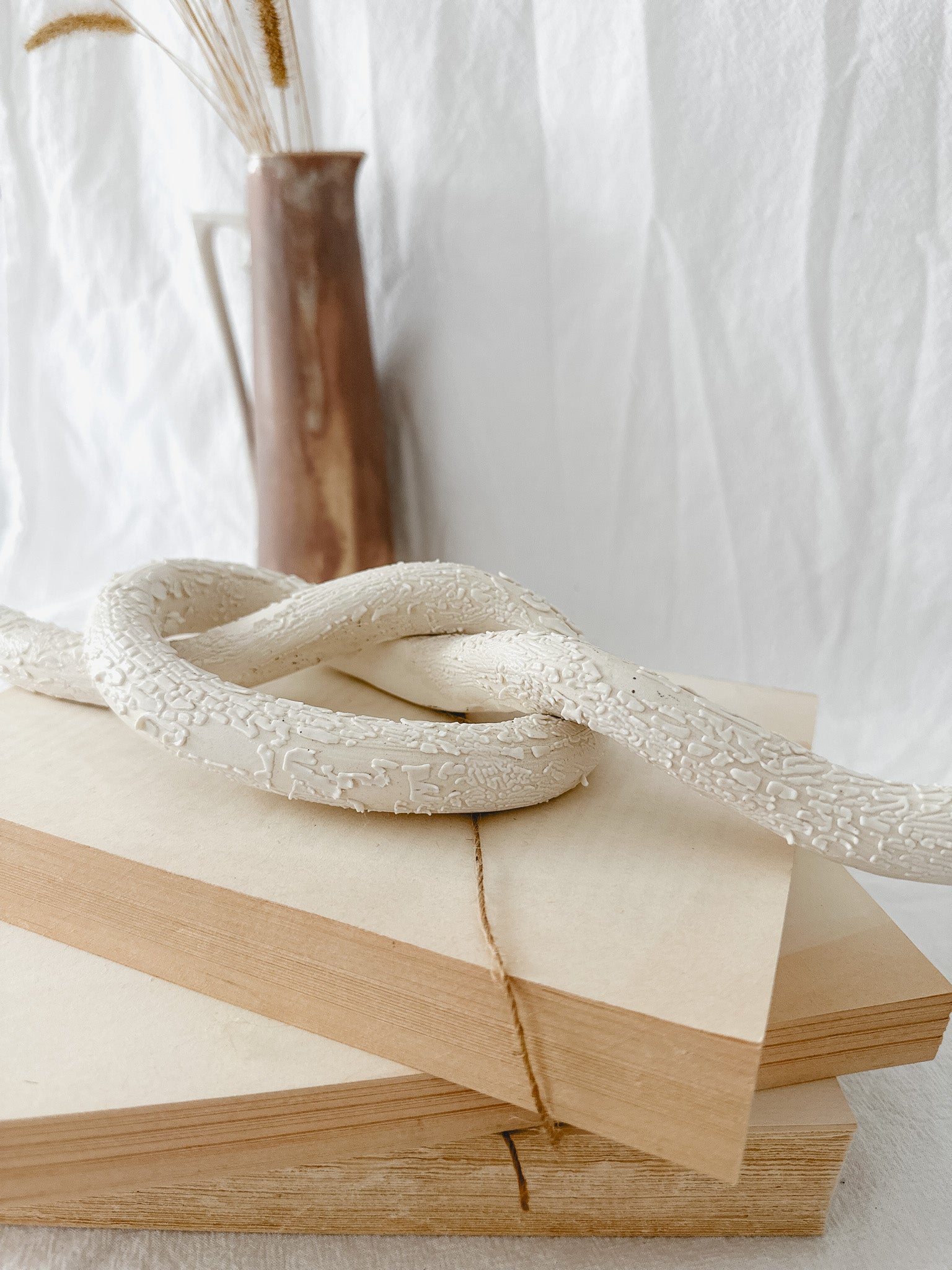 Handmade ceramic love knot decor object in textured white glaze, 12 inches long, one-of-a-kind piece from Muddy Heart