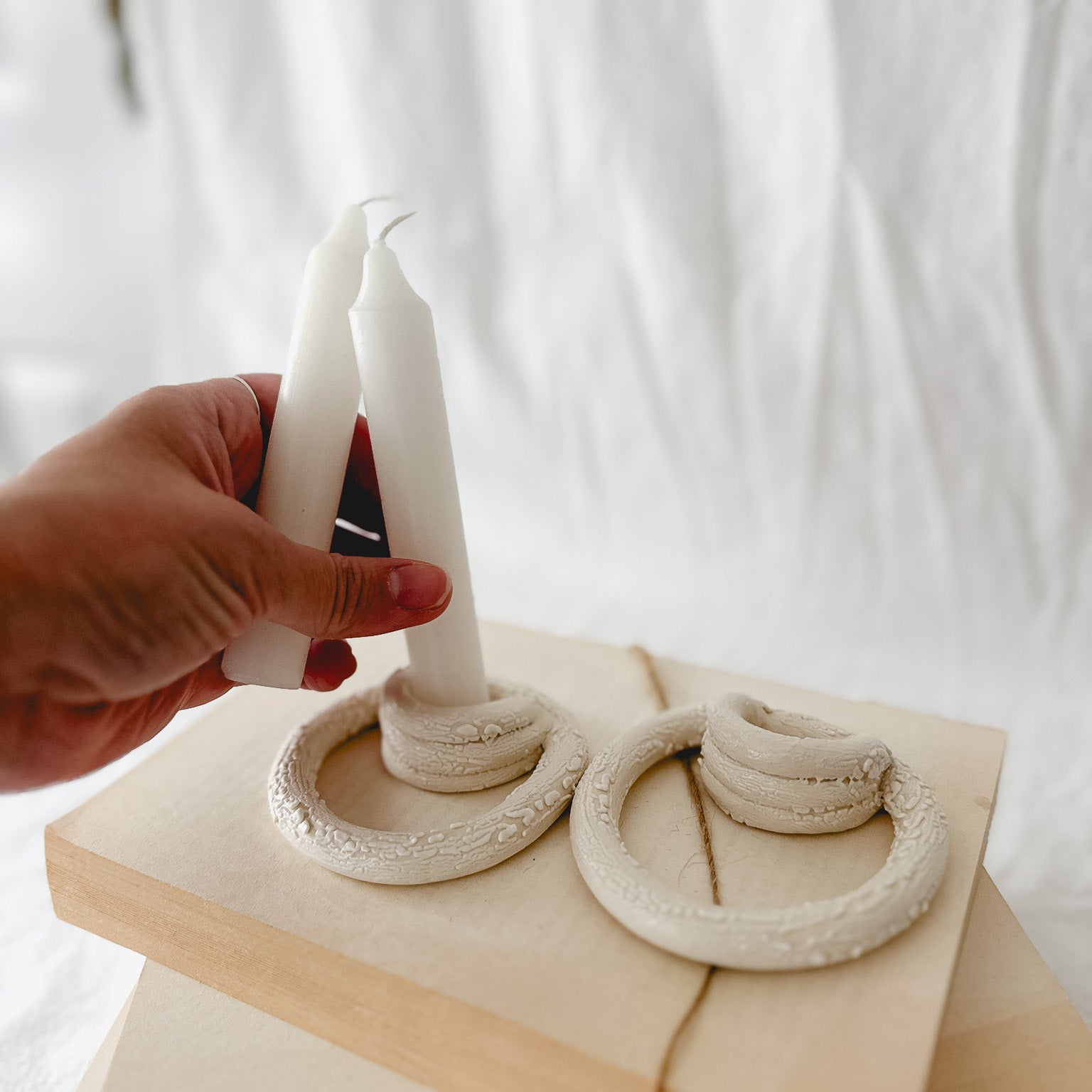 Handmade ceramic taper candle holder formed from interlocking loops, seconds-sale piece from Muddy Heart