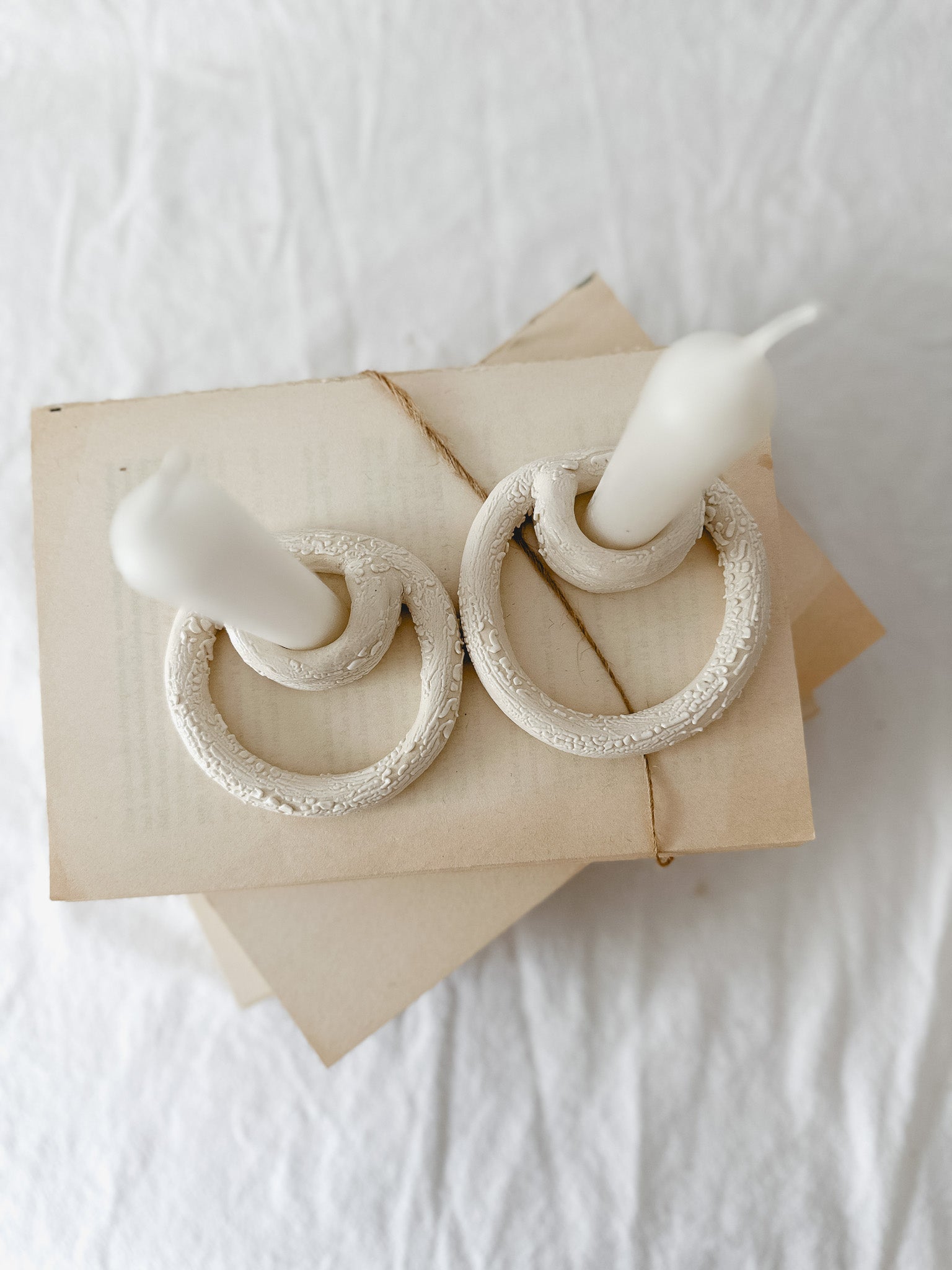 Handmade ceramic taper candle holder formed from interlocking loops, seconds-sale piece from Muddy Heart