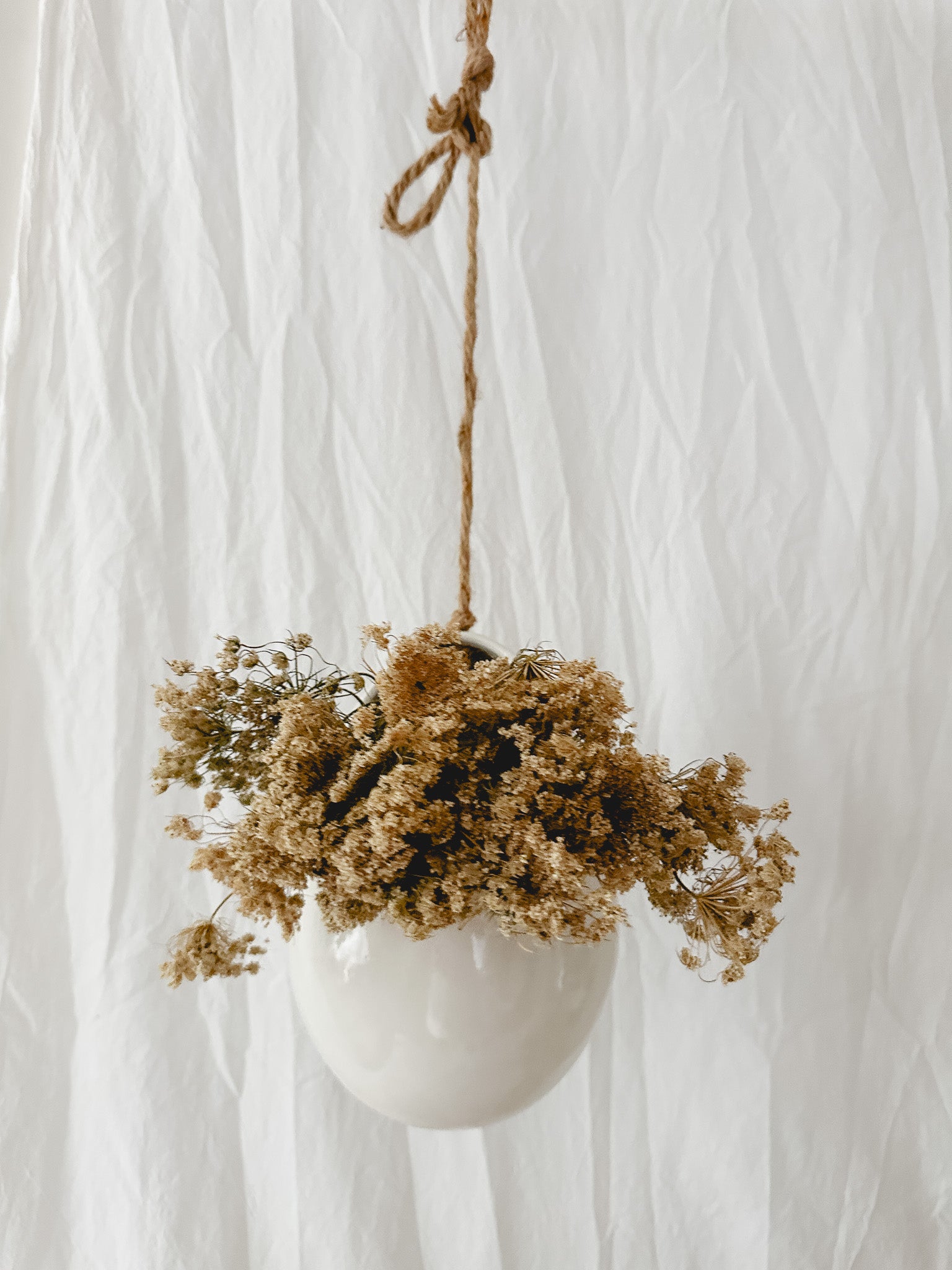 Handmade gloss white ceramic pod-shaped hanging vessel on an 18-inch rope, for flowers or trailing plants, seconds-sale piece from Muddy Heart
