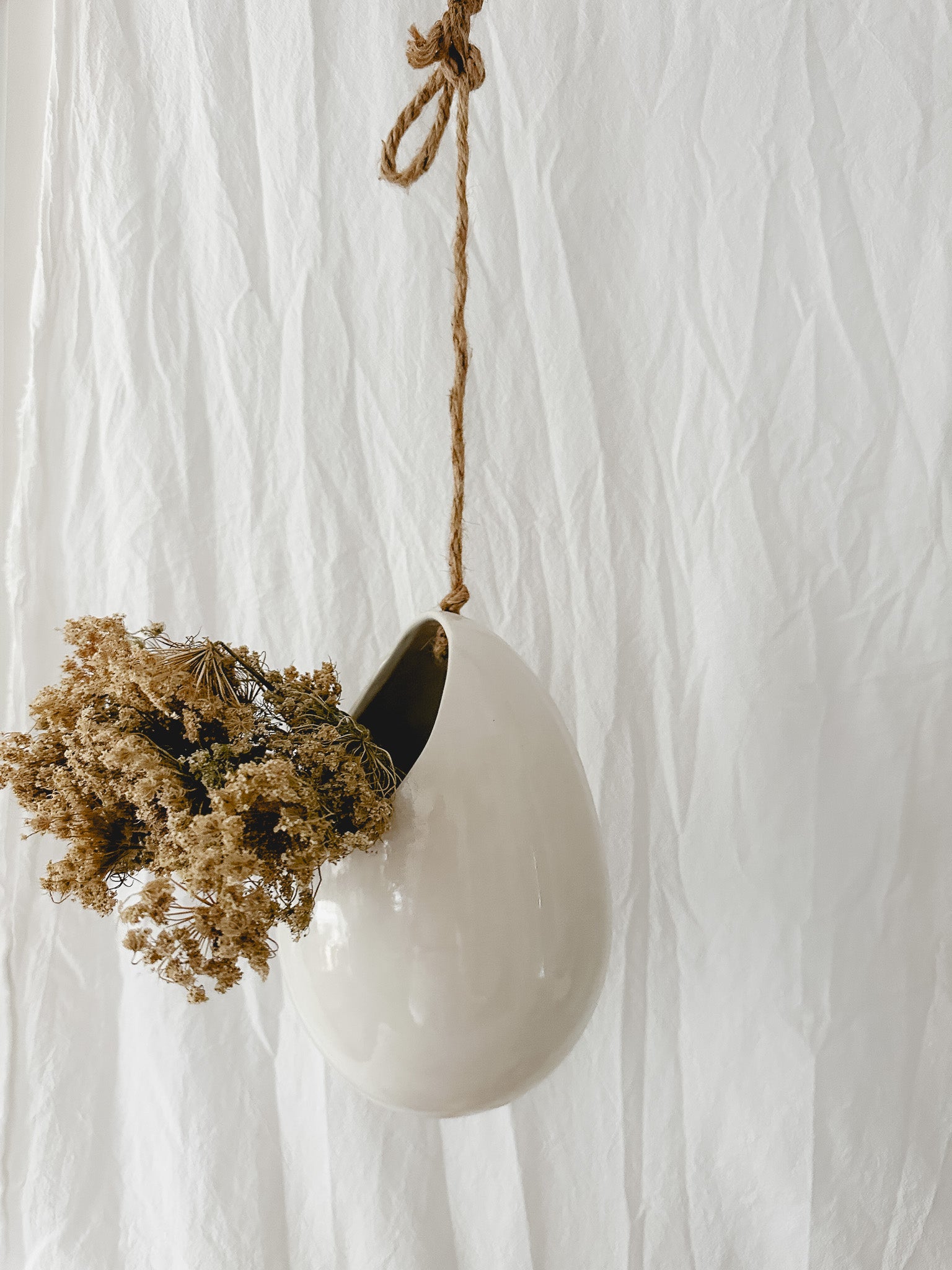 Handmade gloss white ceramic pod-shaped hanging vessel on an 18-inch rope, for flowers or trailing plants, seconds-sale piece from Muddy Heart