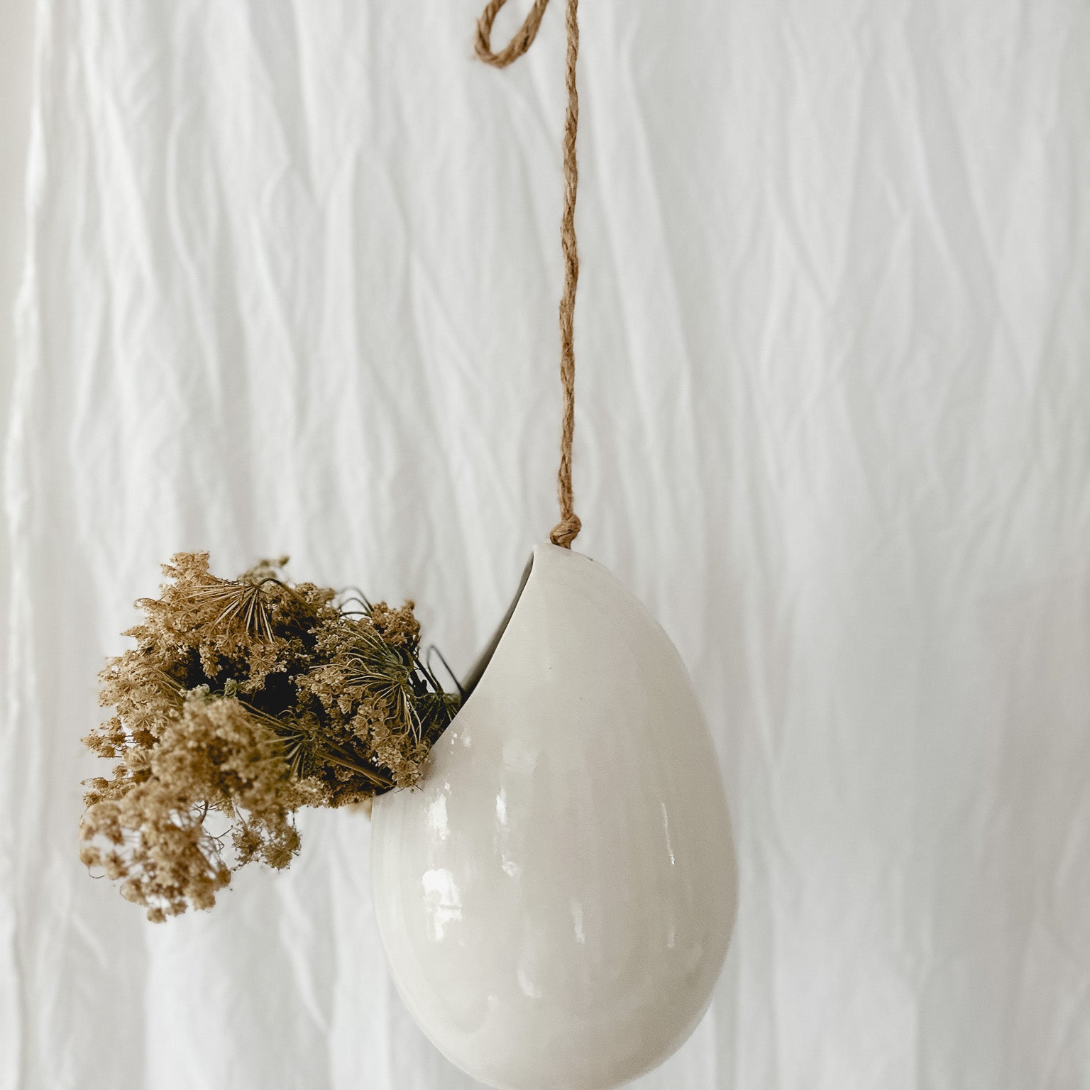 Handmade gloss white ceramic pod-shaped hanging vessel on an 18-inch rope, for flowers or trailing plants, seconds-sale piece from Muddy Heart