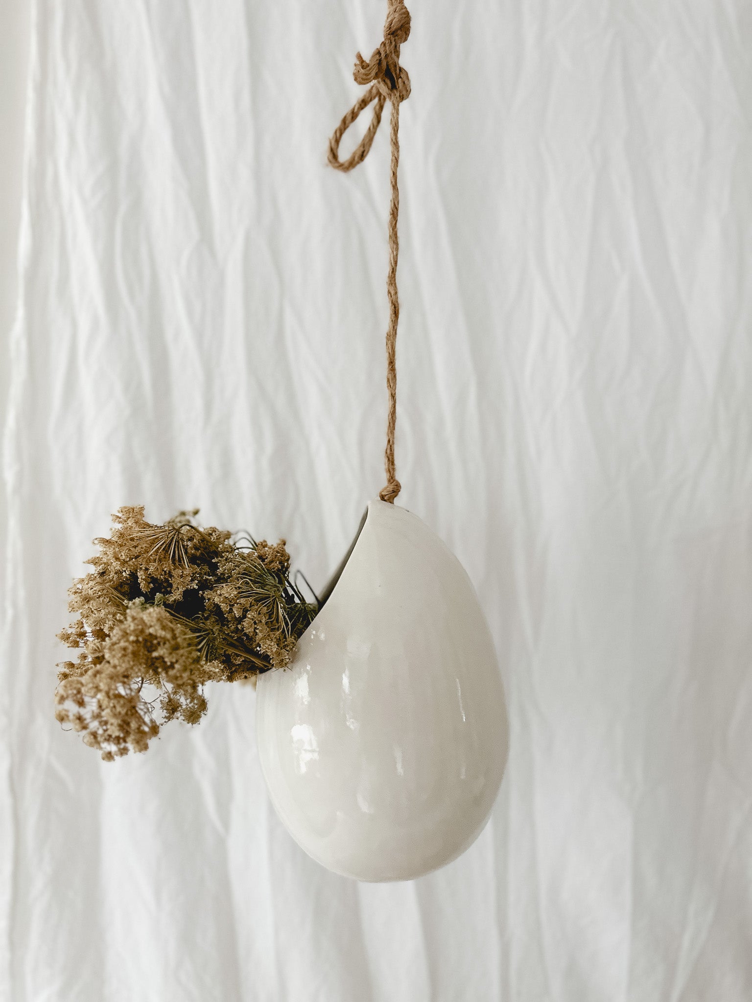 Handmade gloss white ceramic pod-shaped hanging vessel on an 18-inch rope, for flowers or trailing plants, seconds-sale piece from Muddy Heart