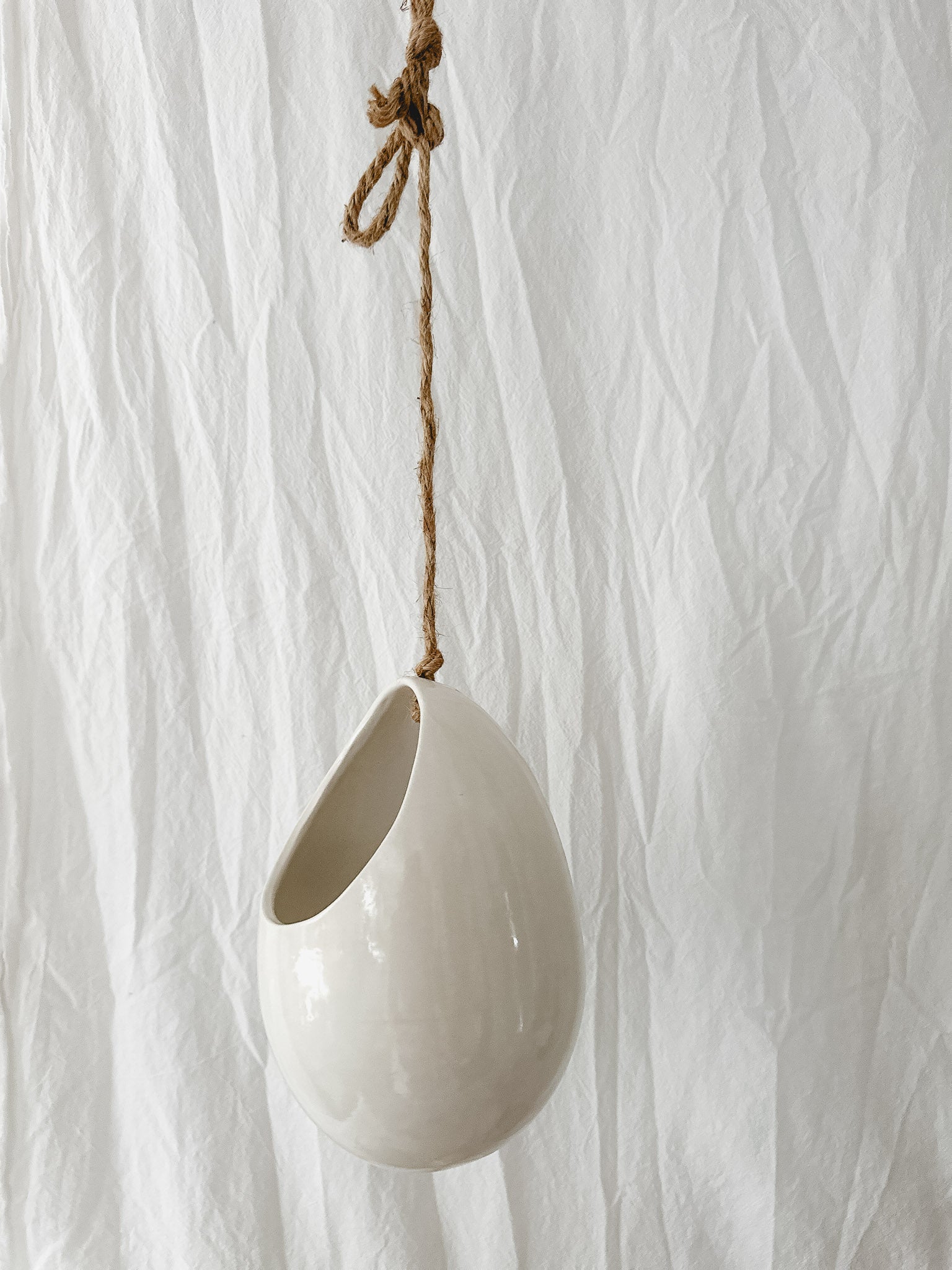 Handmade gloss white ceramic pod-shaped hanging vessel on an 18-inch rope, for flowers or trailing plants, seconds-sale piece from Muddy Heart