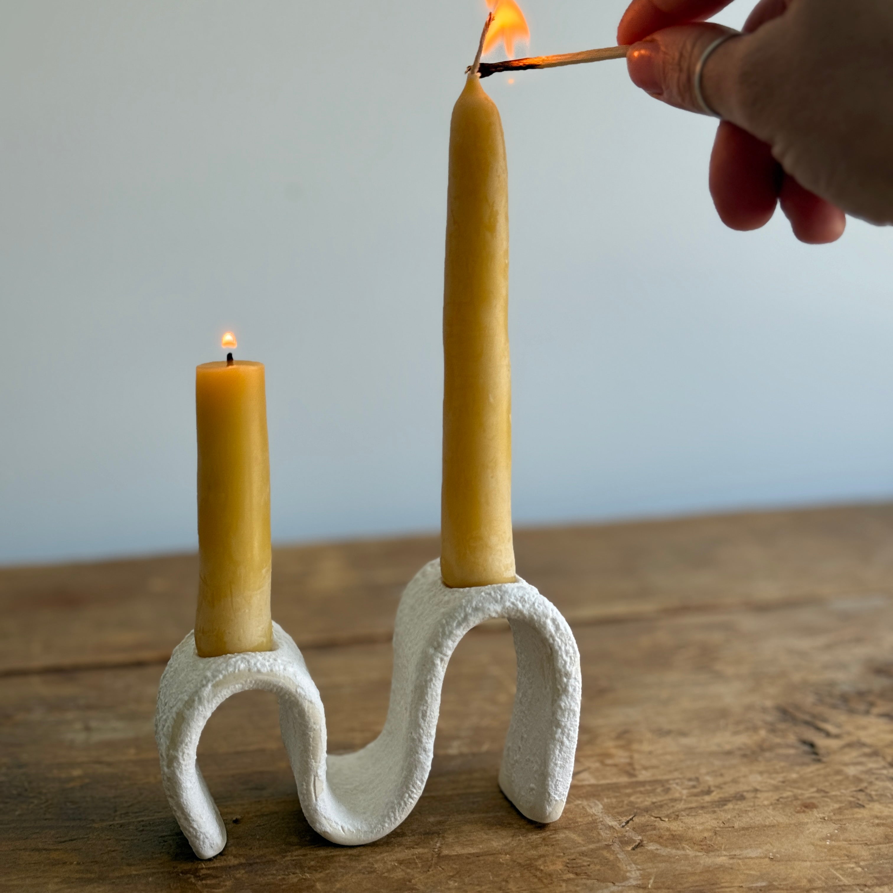 Handmade ceramic wiggle candelabra with organic free-form curves holding two taper candles.
