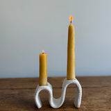 Handmade ceramic wiggle candelabra with organic free-form curves holding two taper candles.