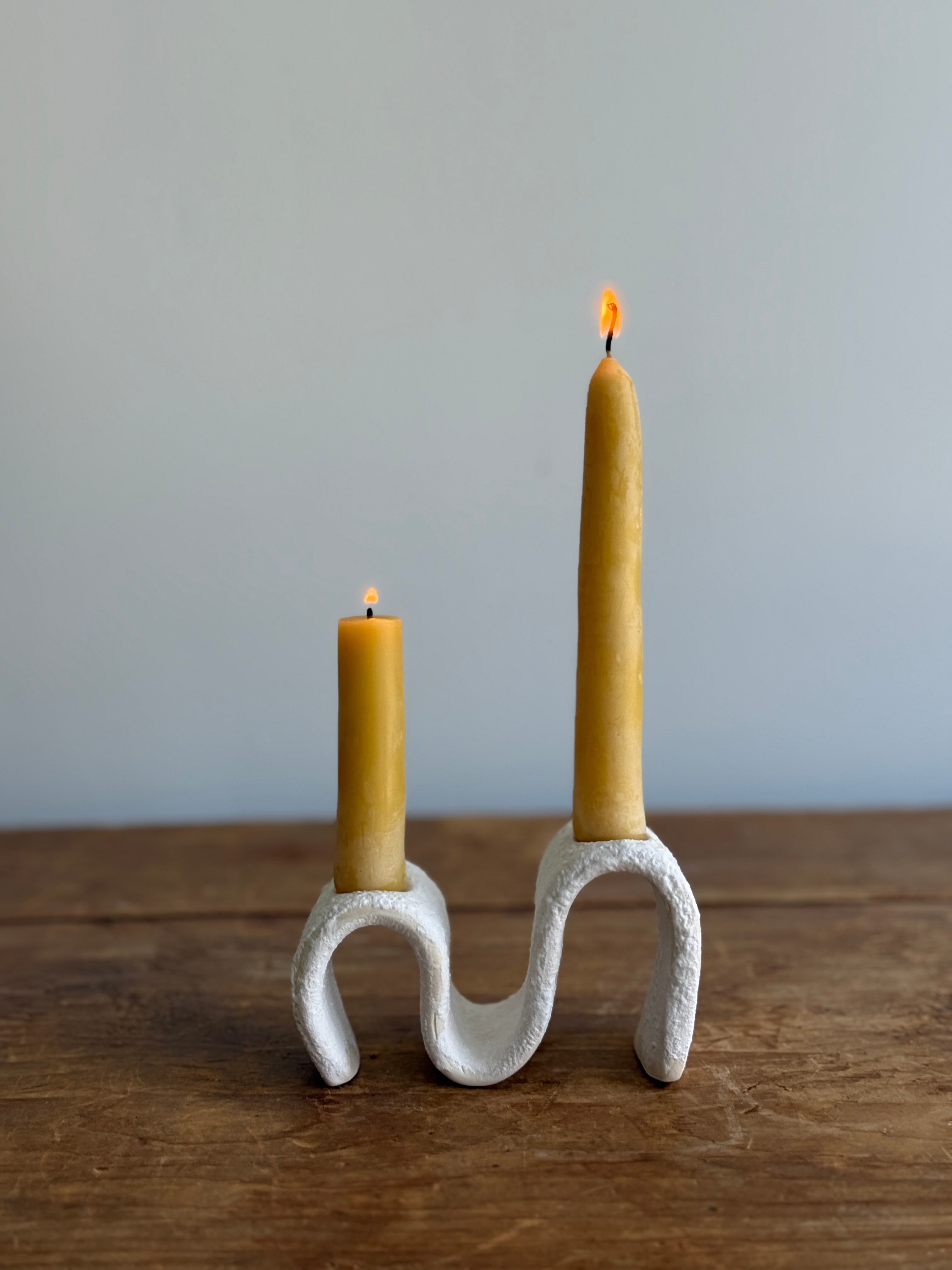 Handmade ceramic wiggle candelabra with organic free-form curves holding two taper candles.