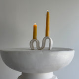 Handmade ceramic wiggle candelabra with organic free-form curves holding two taper candles.
