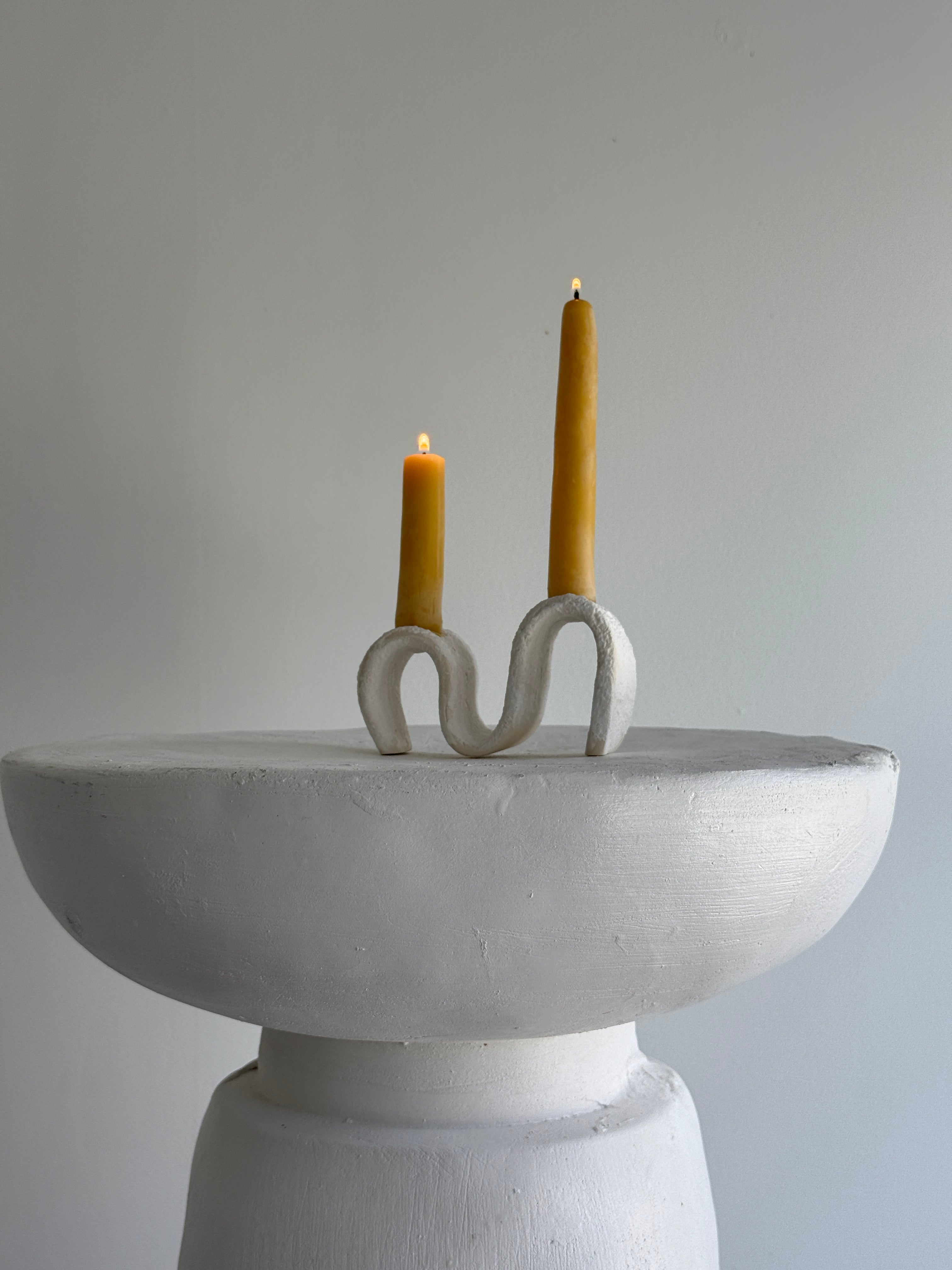 Handmade ceramic wiggle candelabra with organic free-form curves holding two taper candles.