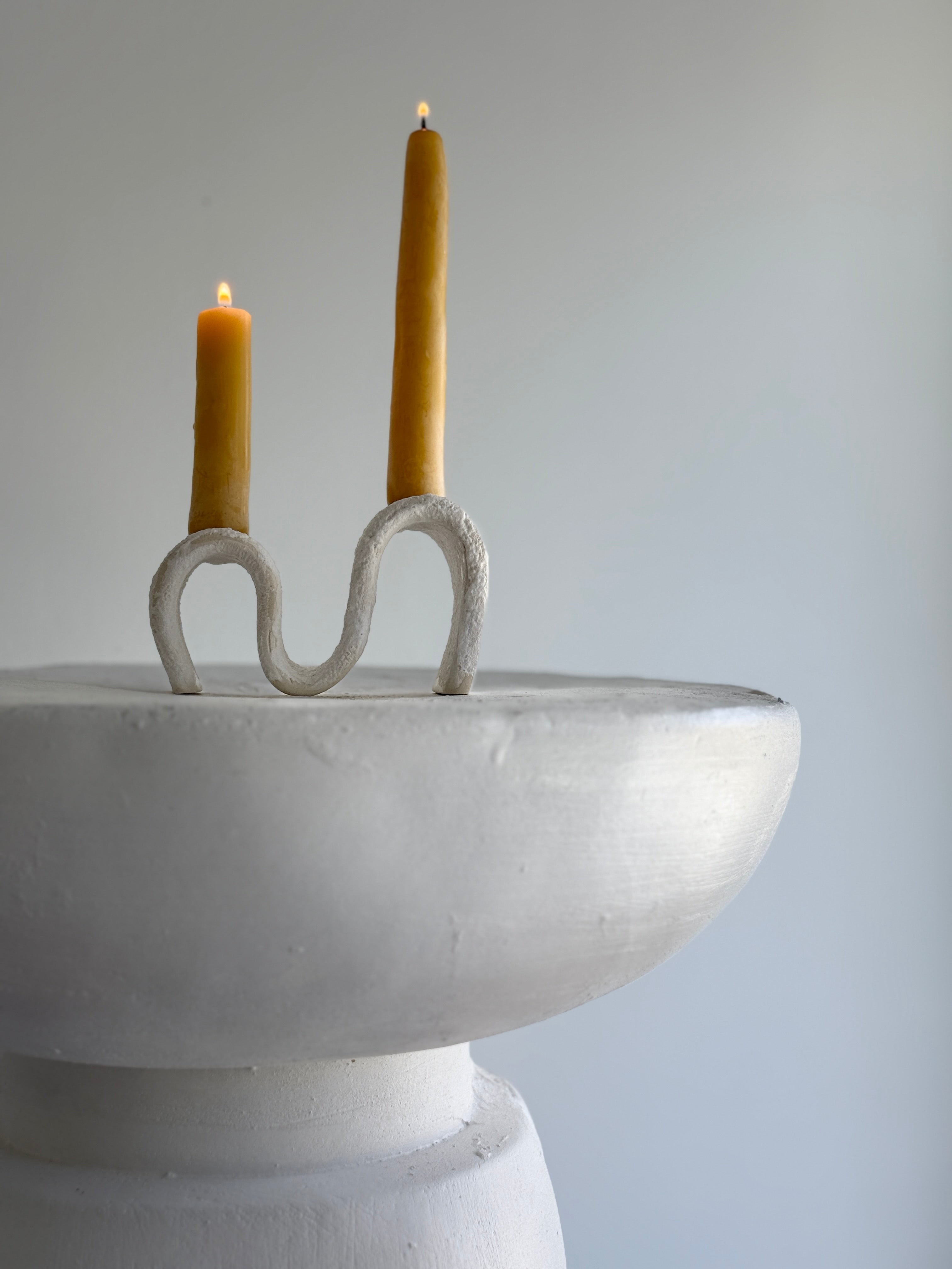 Handmade ceramic wiggle candelabra with organic free-form curves holding two taper candles.