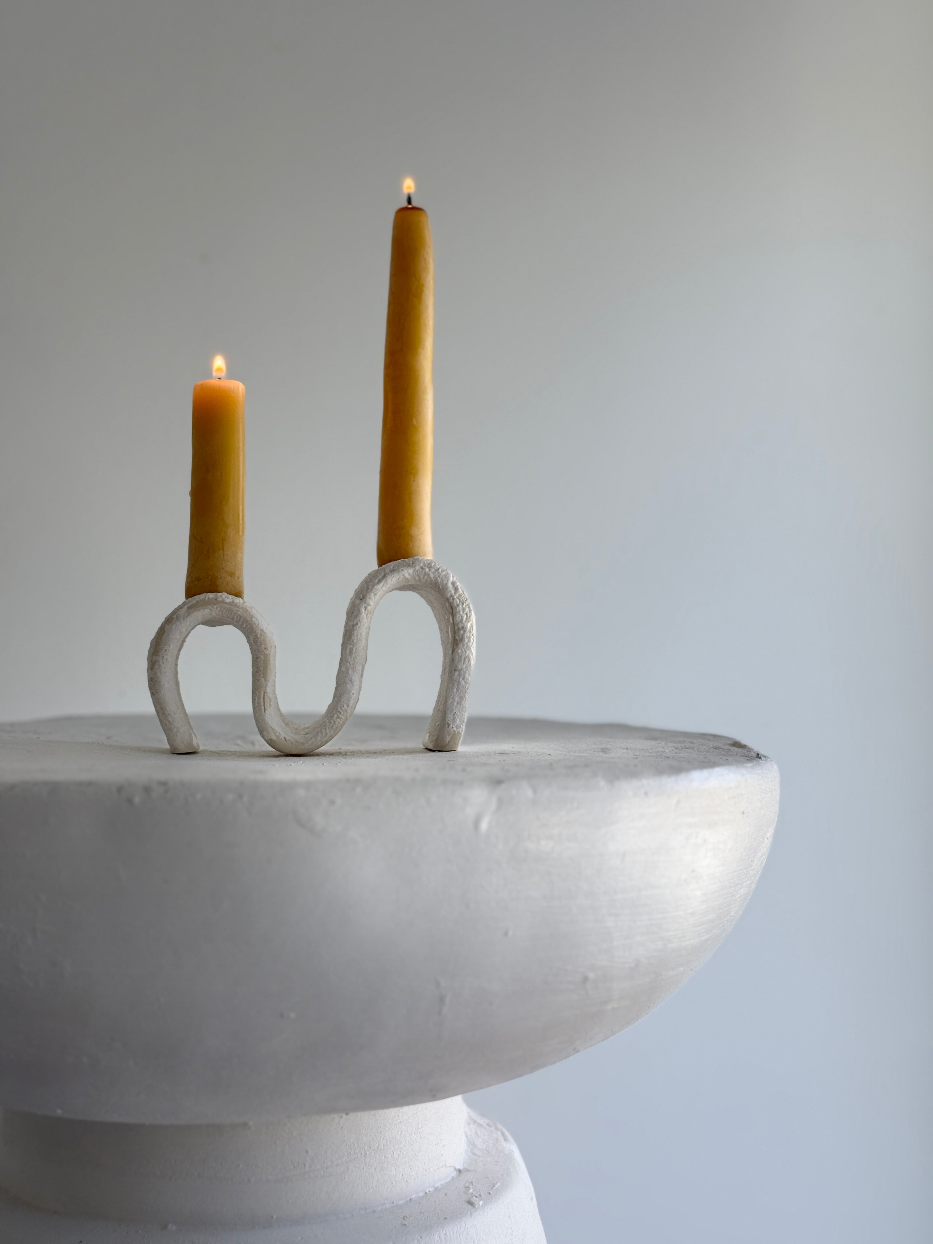 Handmade ceramic wiggle candelabra with organic free-form curves holding two taper candles.