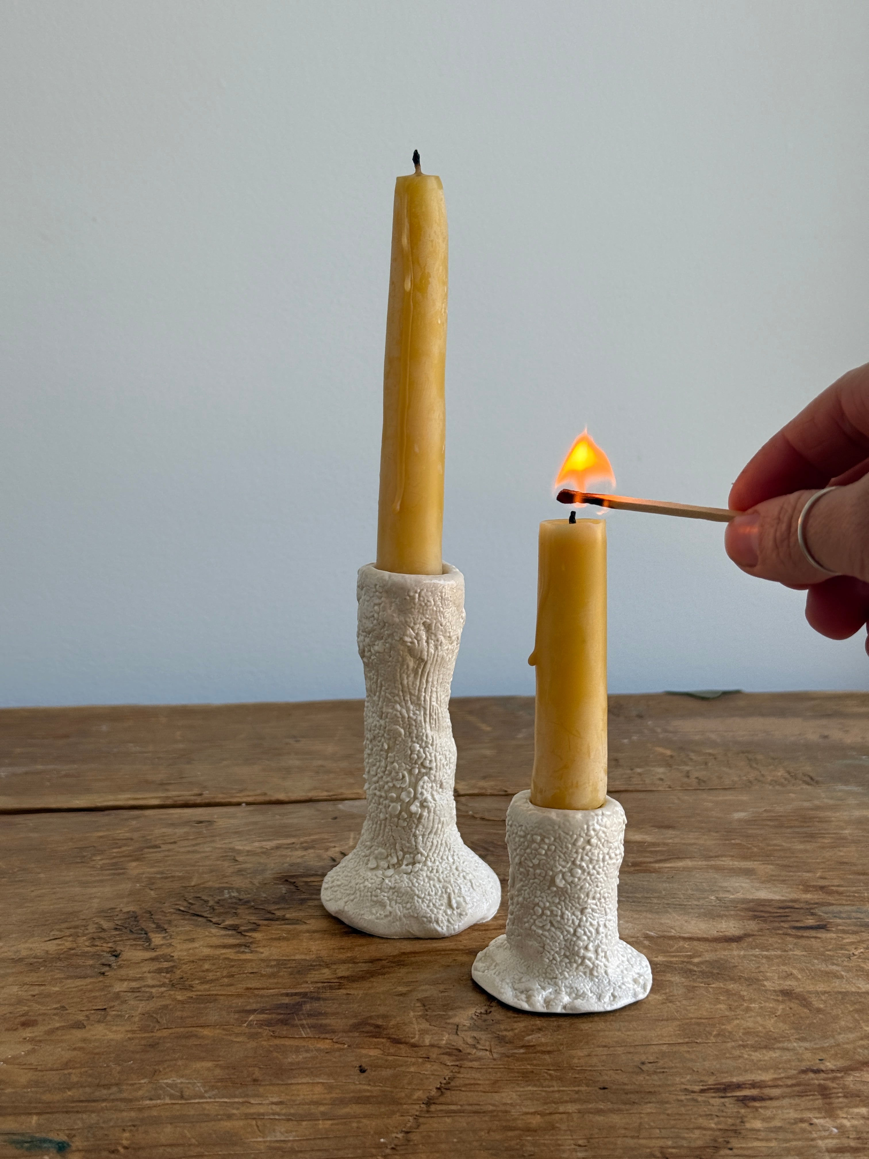Trio of handmade ceramic candlesticks in varied heights for taper candles.
