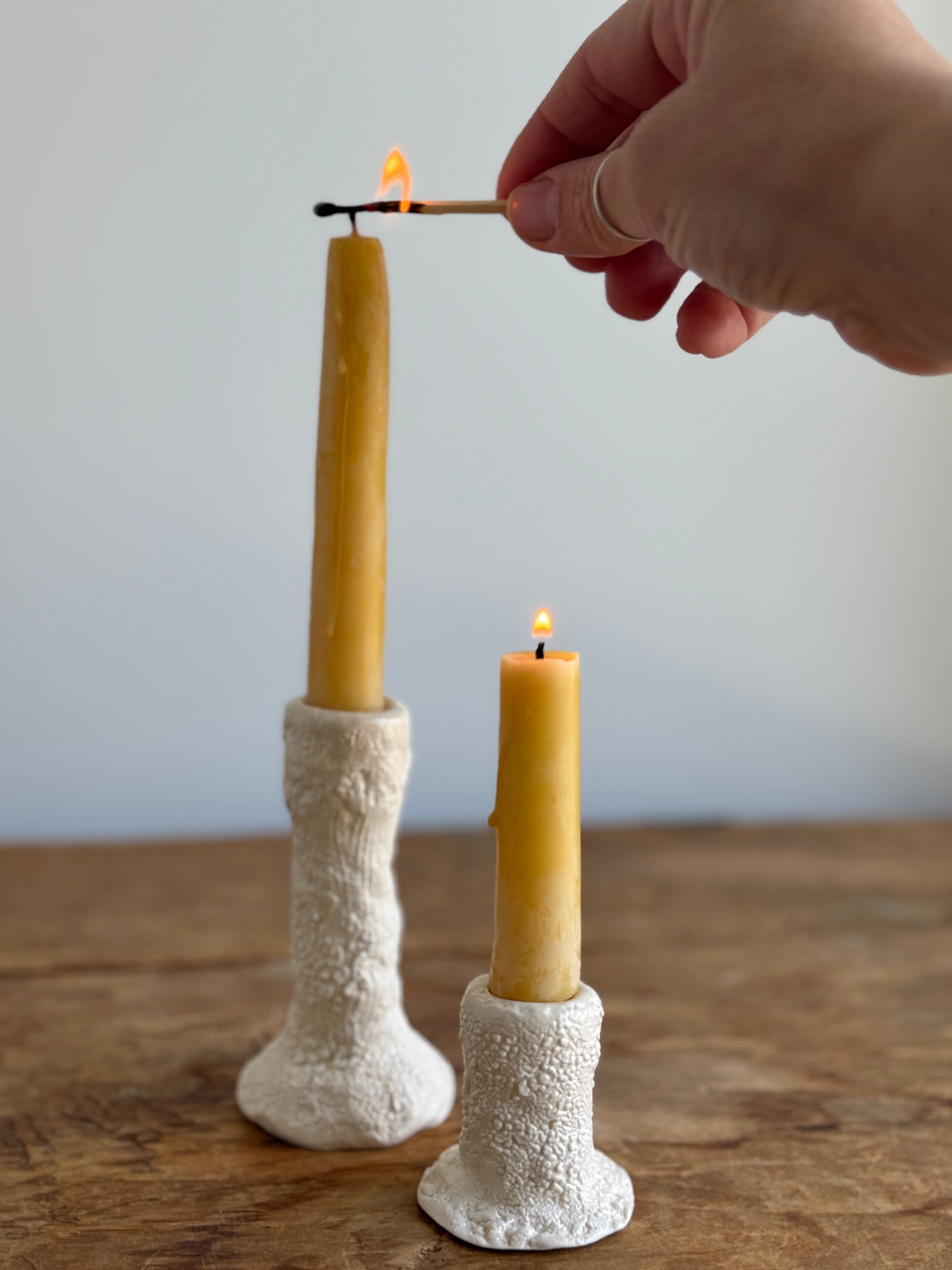 Trio of handmade ceramic candlesticks in varied heights for taper candles.