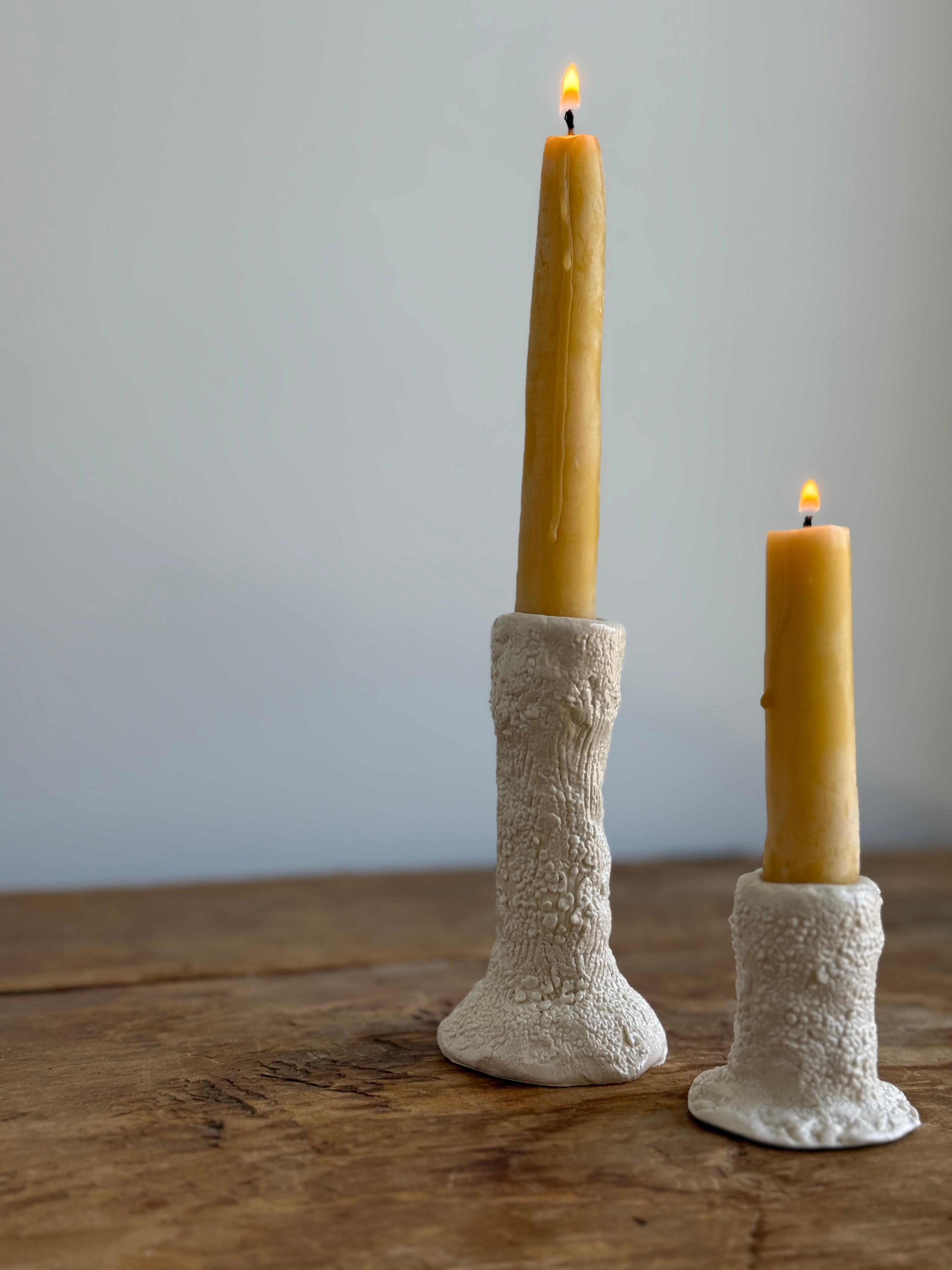 Trio of handmade ceramic candlesticks in varied heights for taper candles.