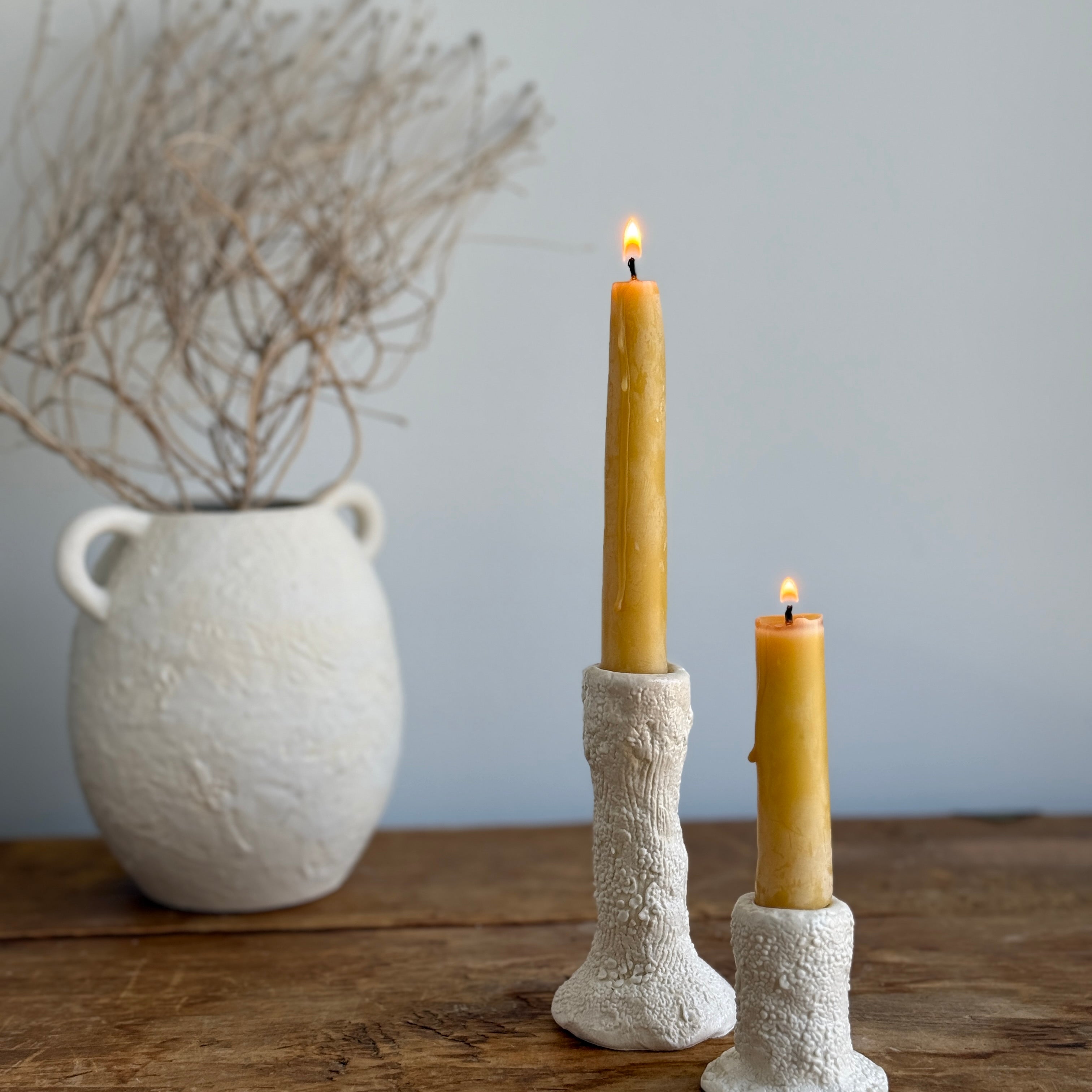 Trio of handmade ceramic candlesticks in varied heights for taper candles.