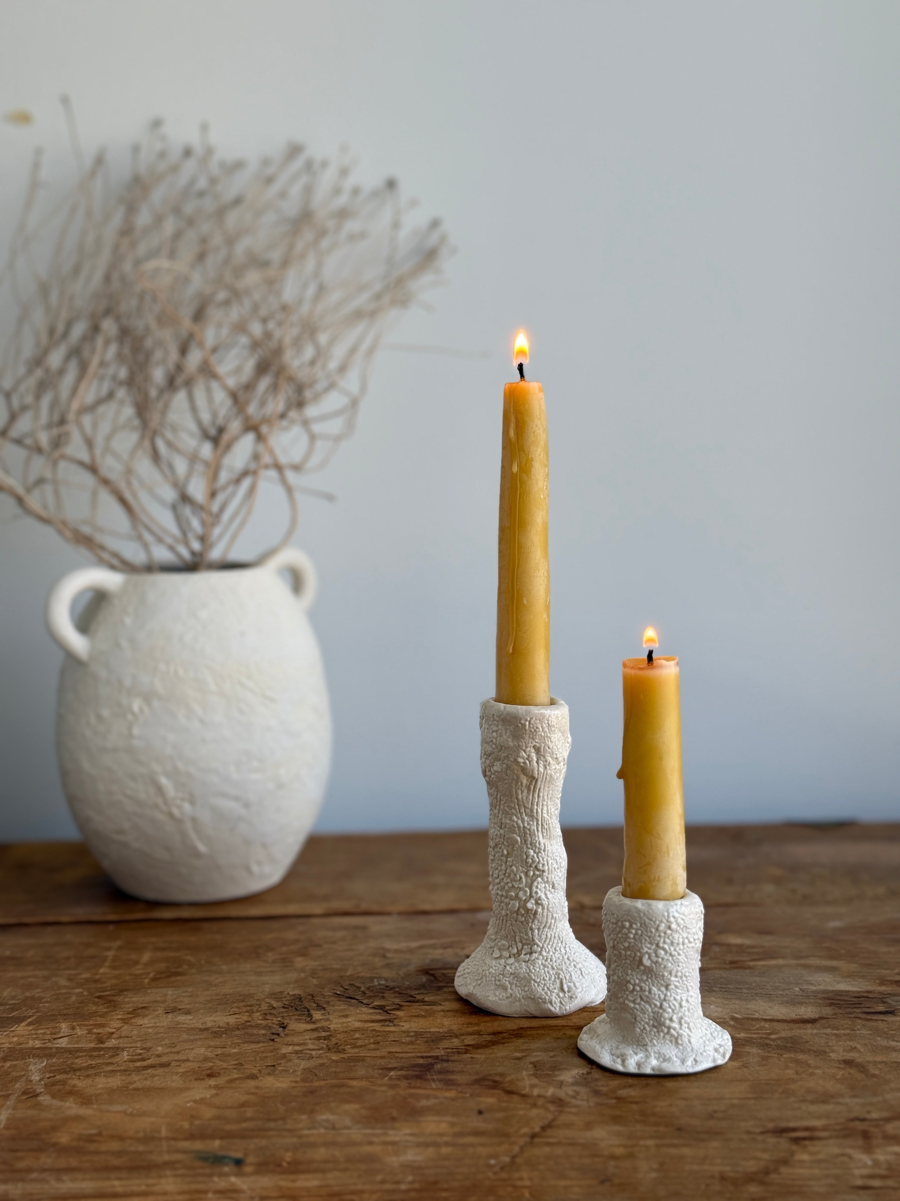 Trio of handmade ceramic candlesticks in varied heights for taper candles.