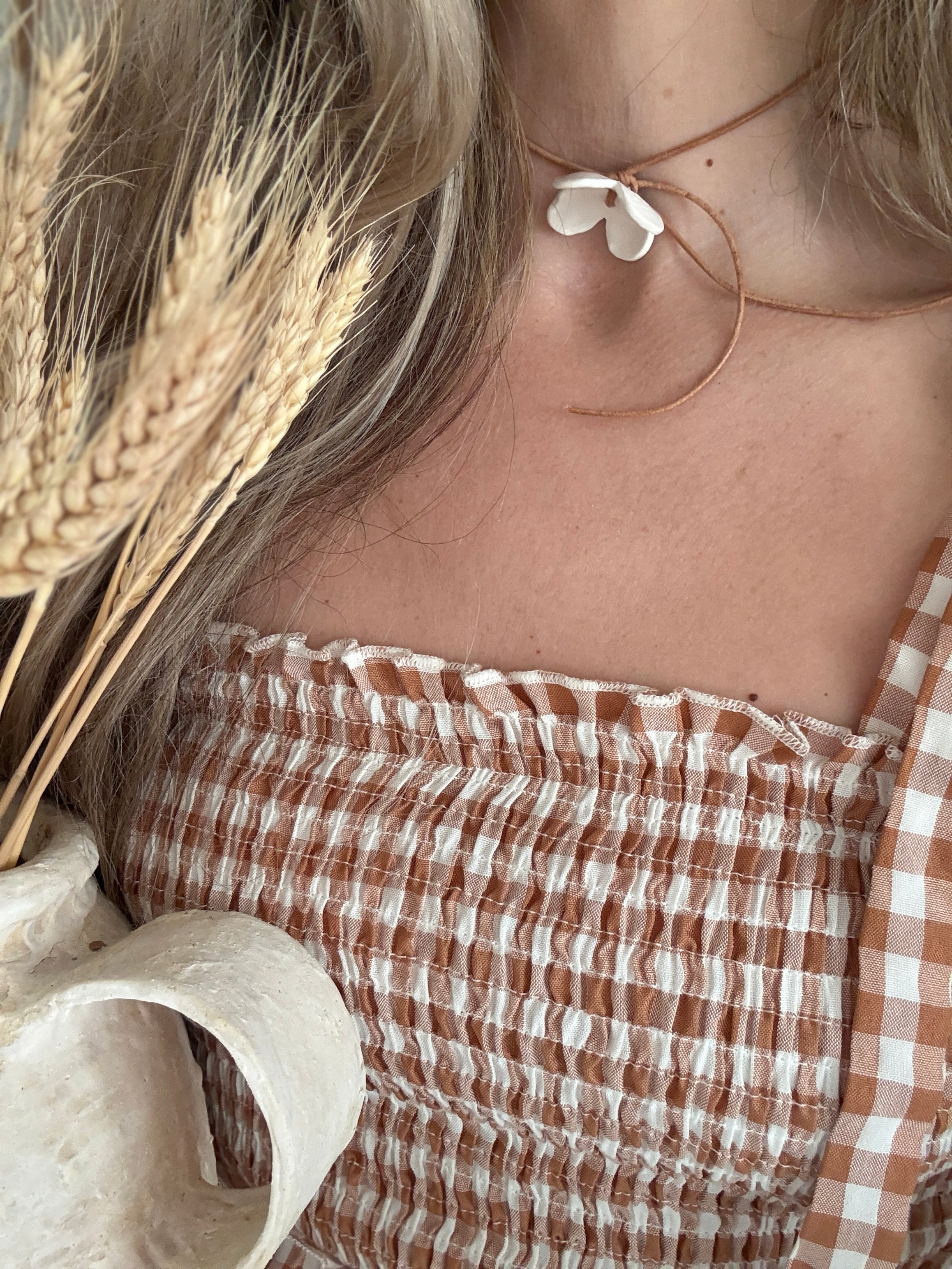 Handmade porcelain dogwood flower choker necklace on an adjustable leather cord.