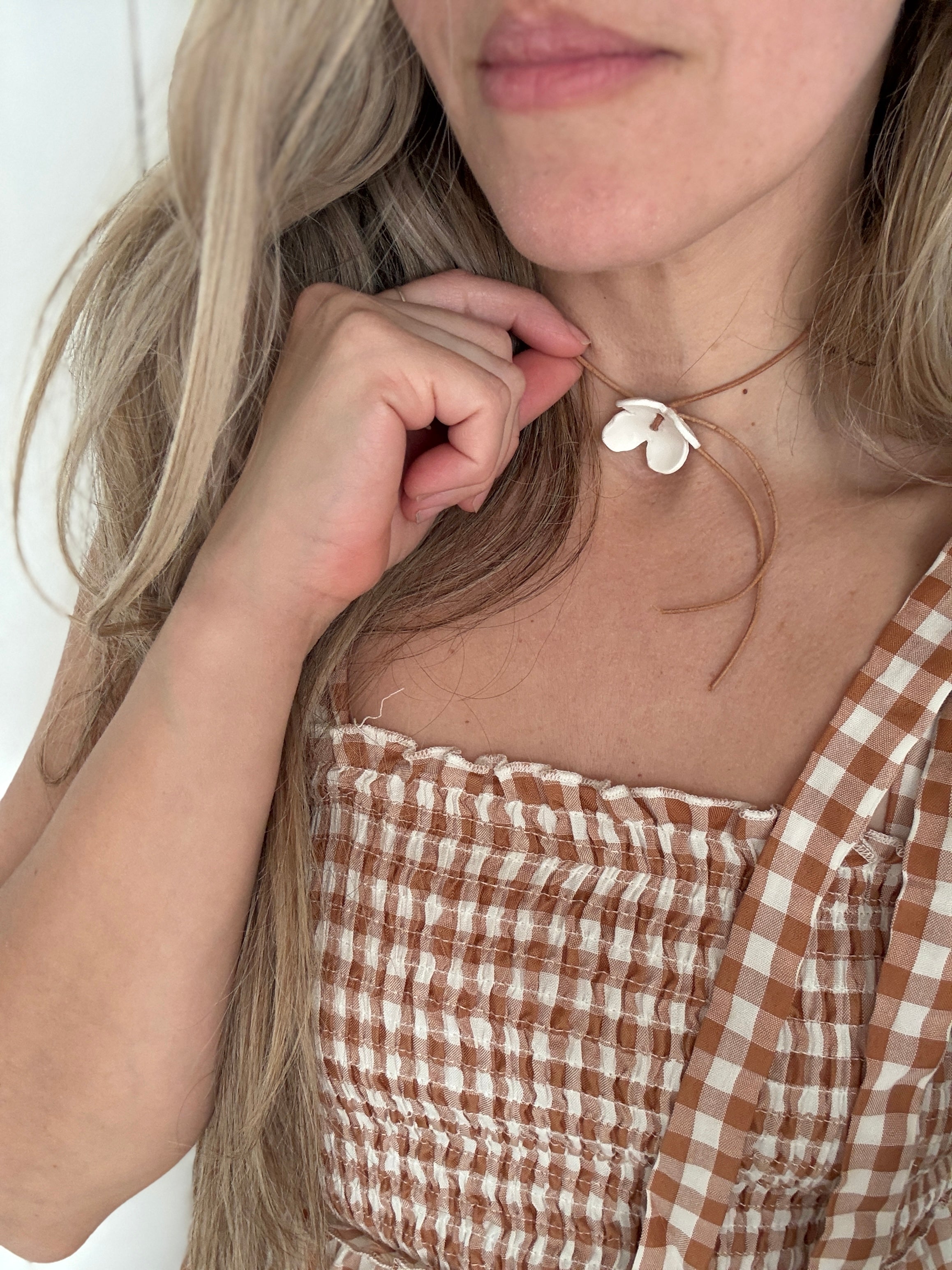 Handmade porcelain dogwood flower choker necklace on an adjustable leather cord.