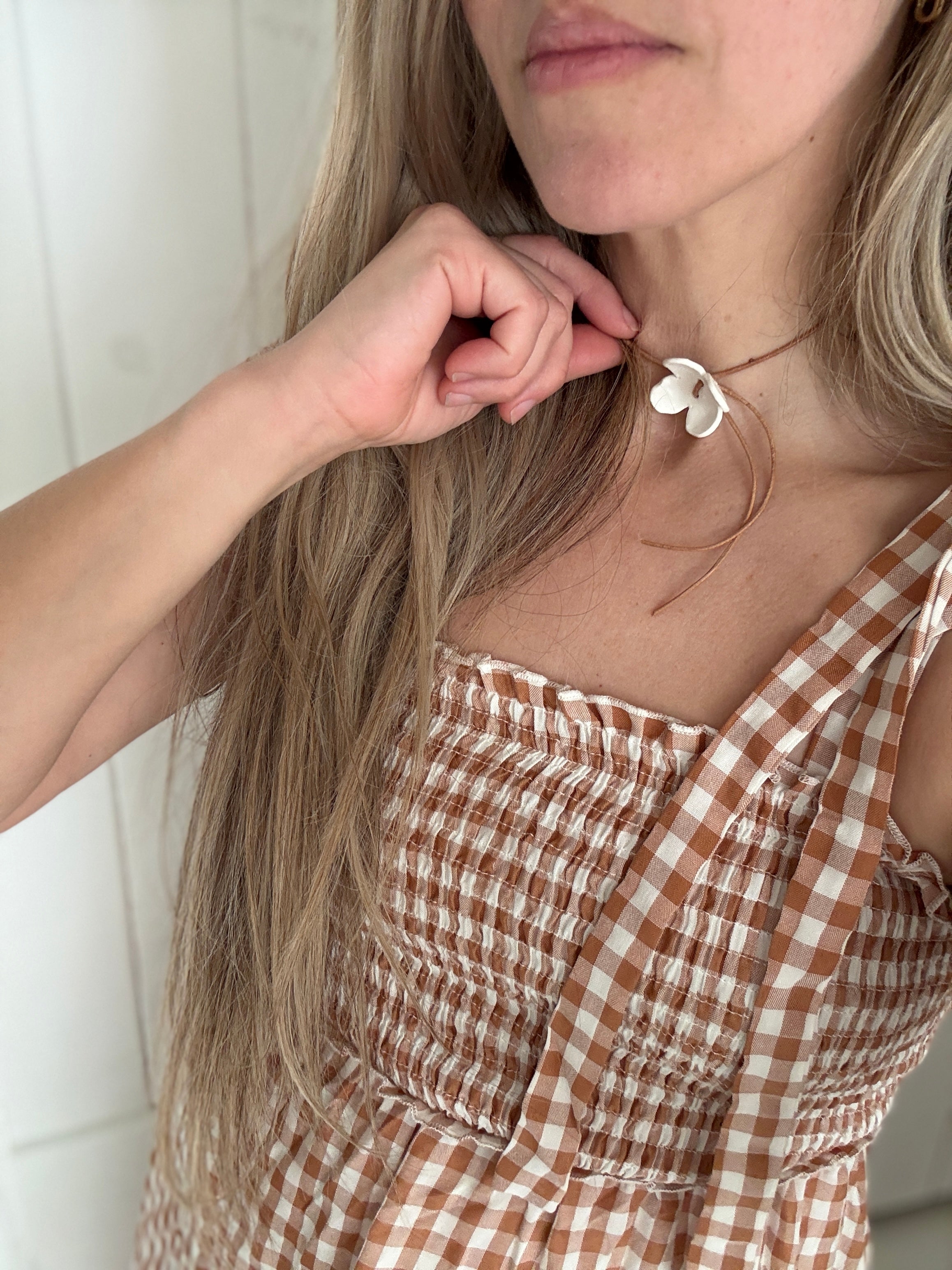 Handmade porcelain dogwood flower choker necklace on an adjustable leather cord.
