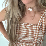 Handmade porcelain dogwood flower choker necklace on an adjustable leather cord.