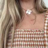 Handmade porcelain dogwood flower choker necklace on an adjustable leather cord.