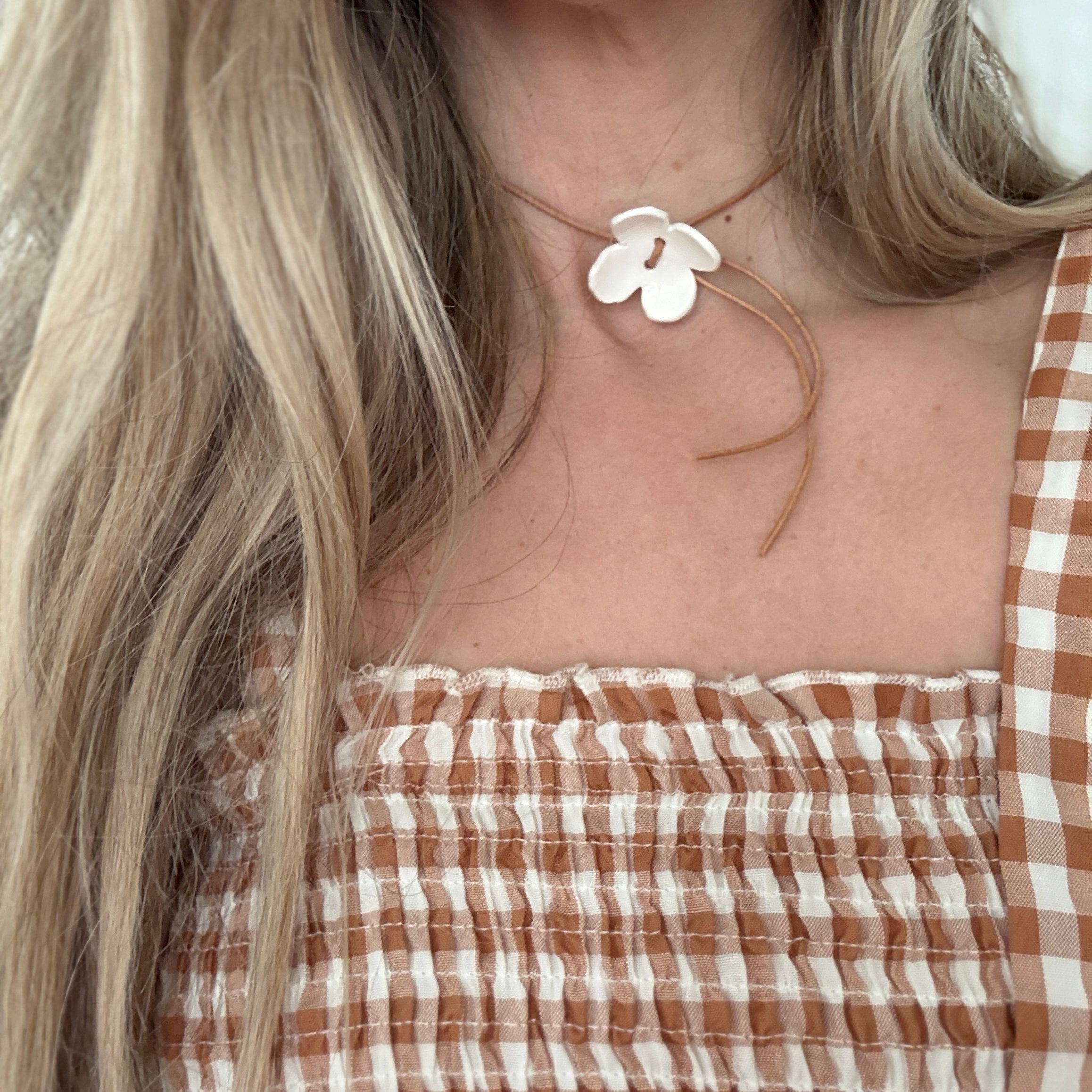 Handmade porcelain dogwood flower choker necklace on an adjustable leather cord.