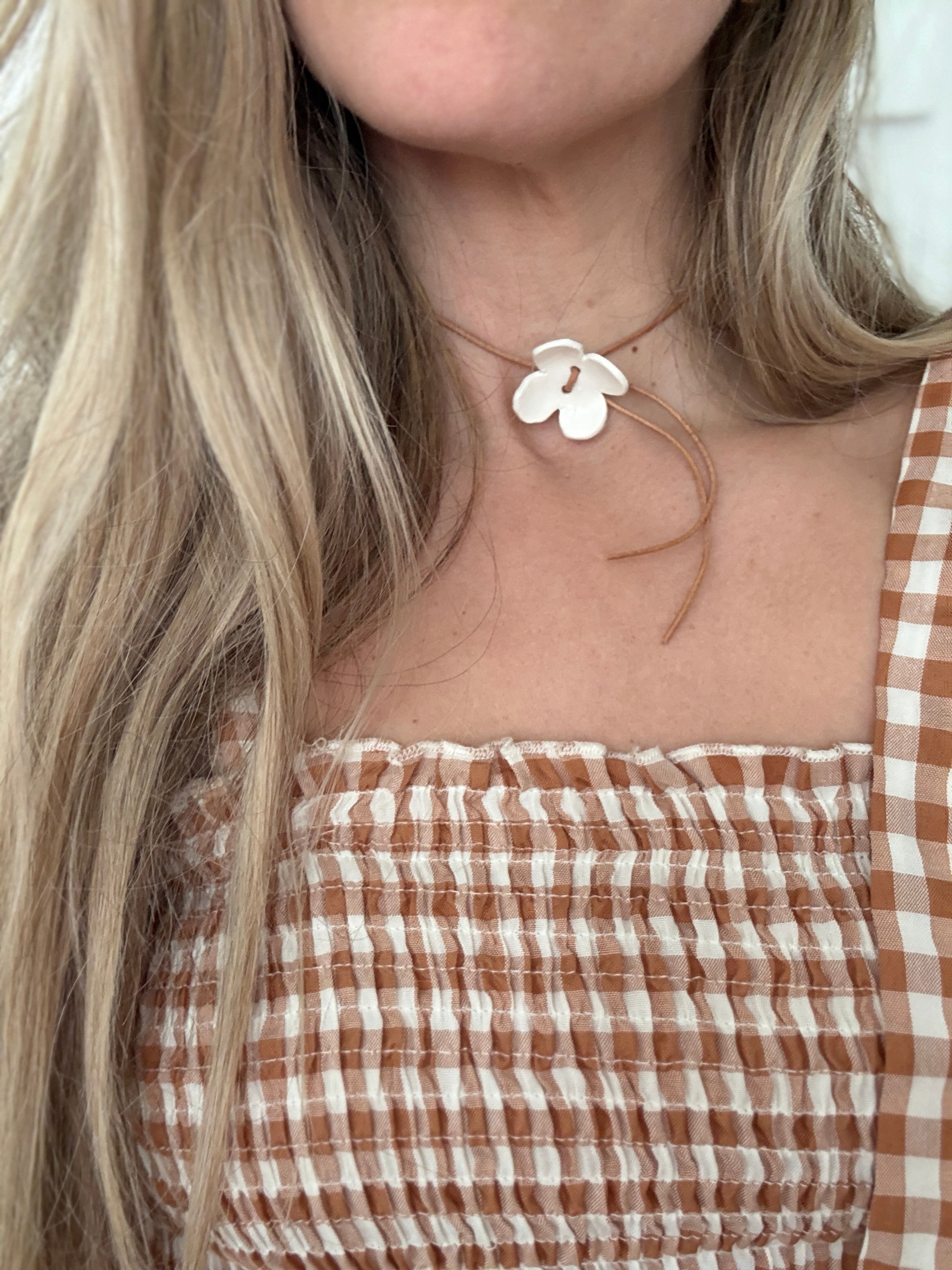 Handmade porcelain dogwood flower choker necklace on an adjustable leather cord.