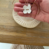 Handmade porcelain dogwood flower choker necklace on an adjustable leather cord.