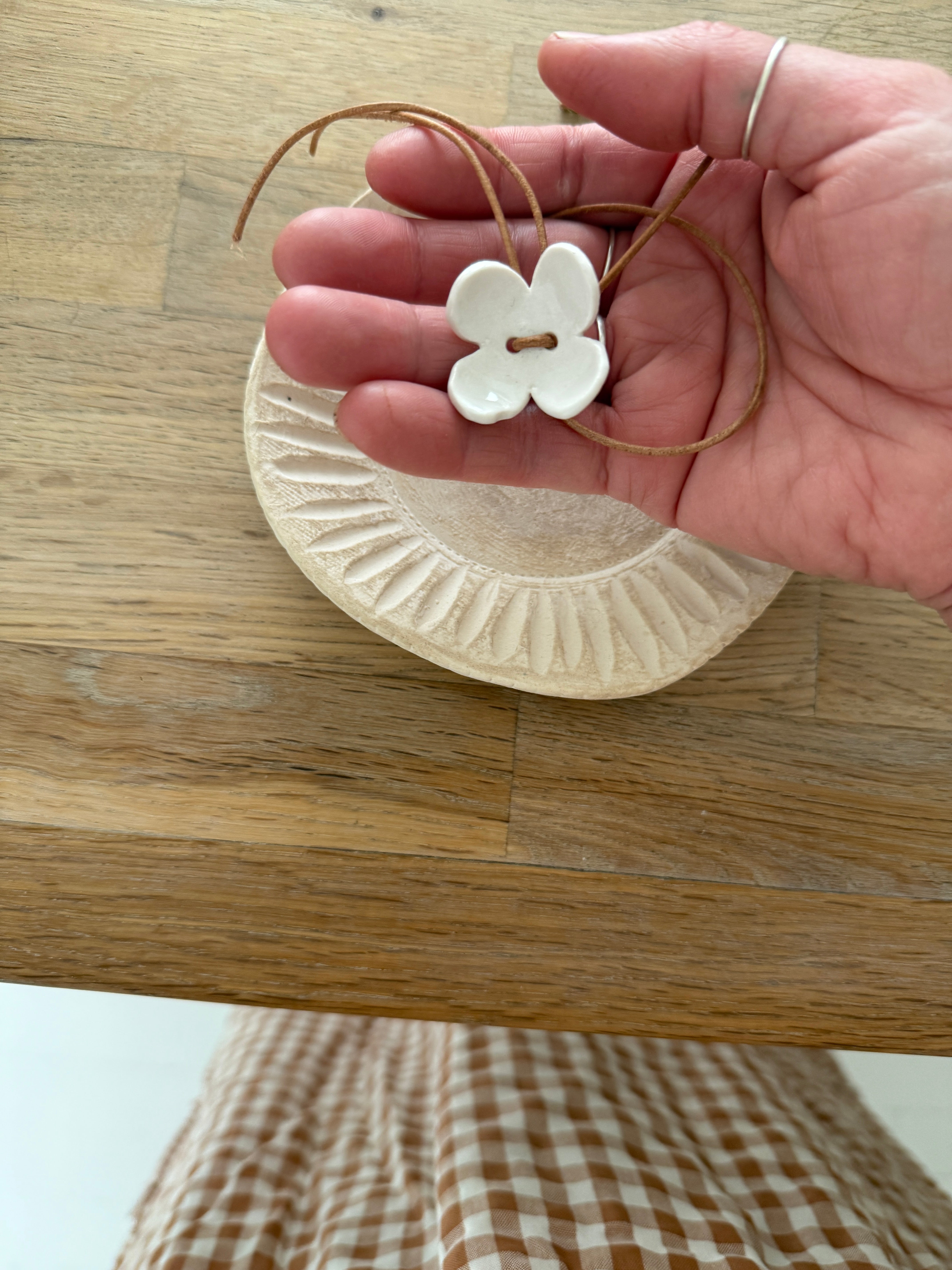 Handmade porcelain dogwood flower choker necklace on an adjustable leather cord.