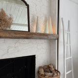 Handmade stoneware tree luminary with star cutouts glowing from an LED tea light