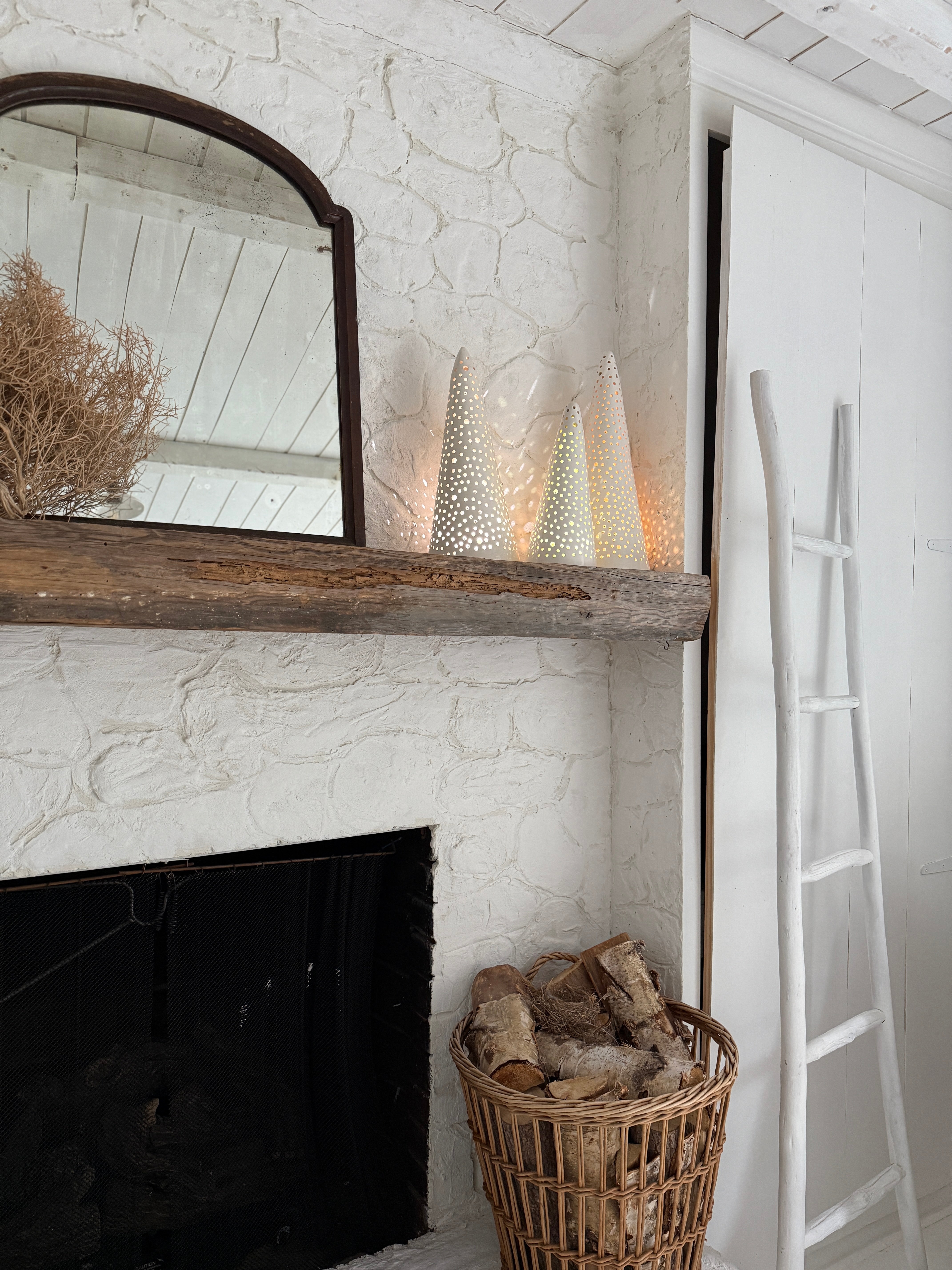 Handmade stoneware tree luminary with star cutouts glowing from an LED tea light